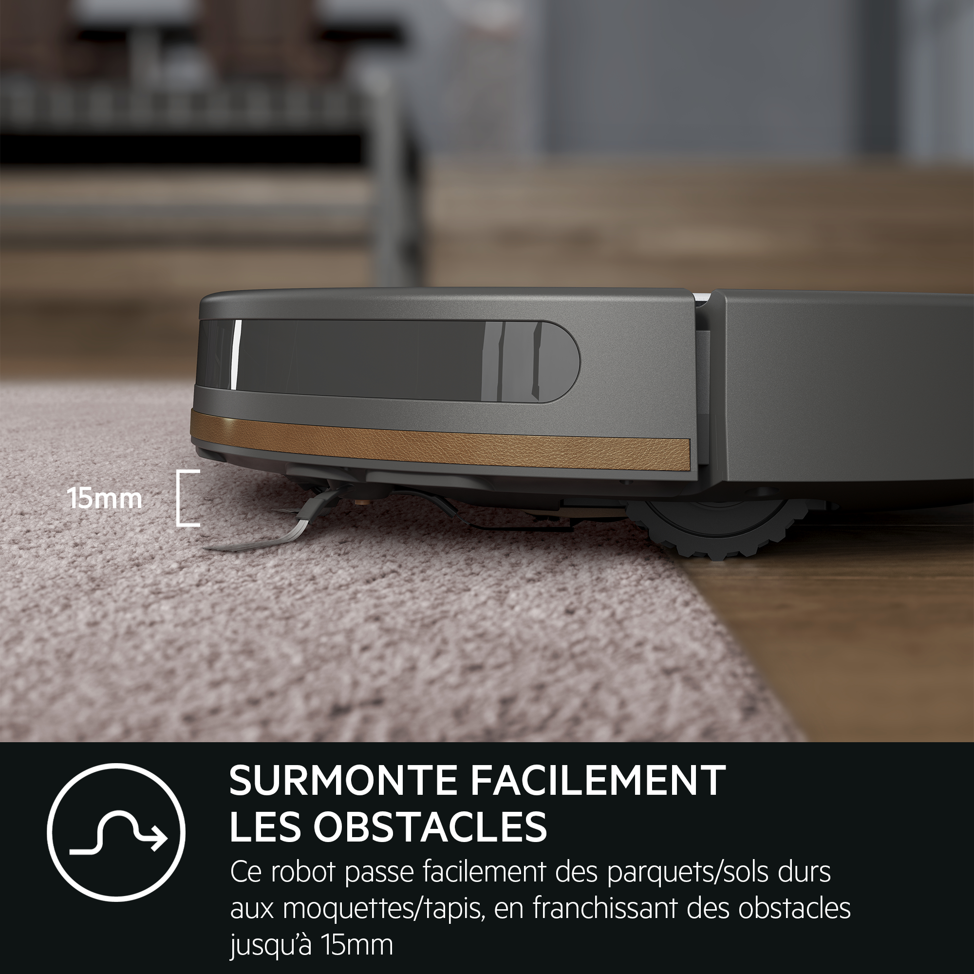 Gros plan d'un aspirateur robot se déplaçant d'un tapis à un plancher en bois franc.