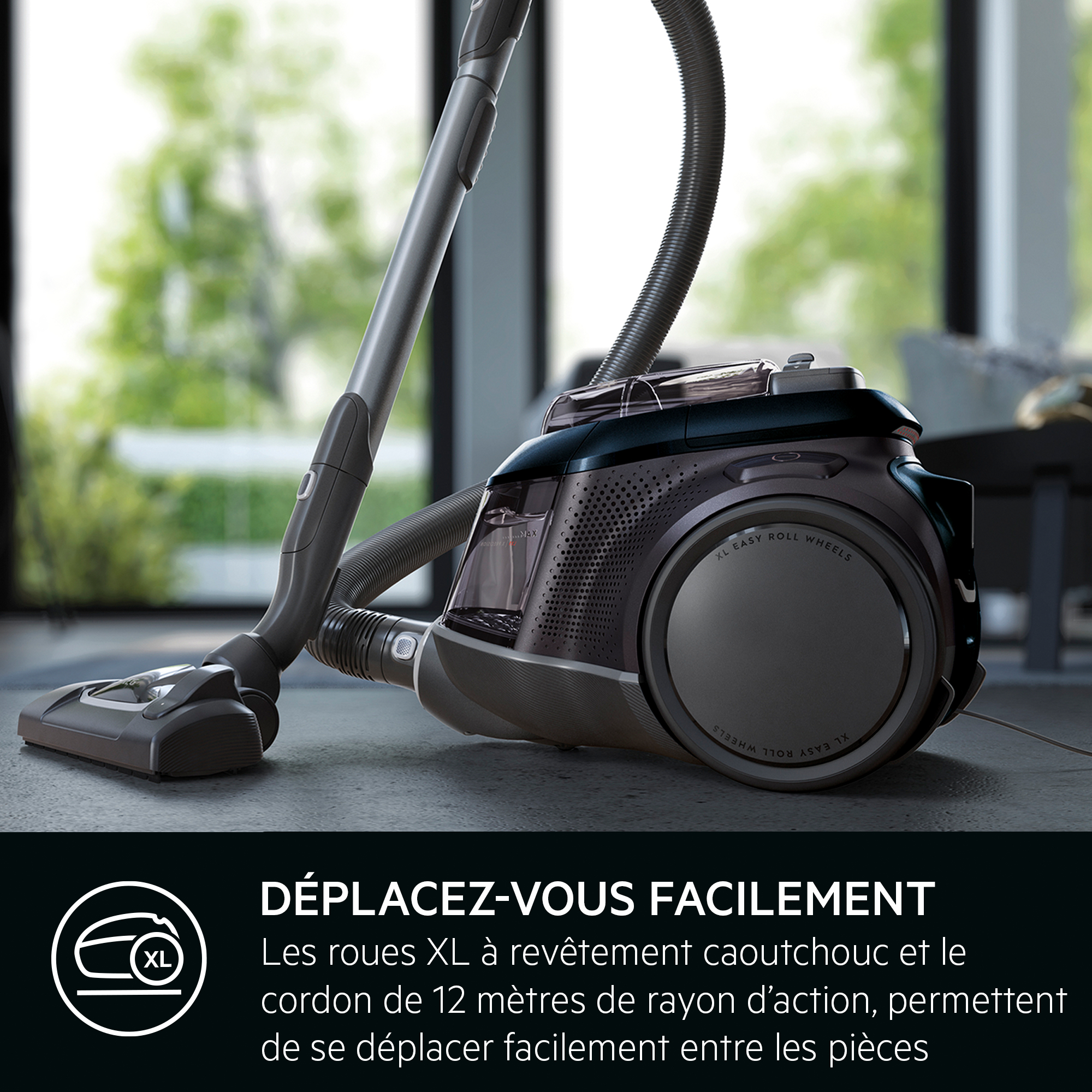 Aspirateur avec texte, sur sol sombre, près d'une fenêtre.