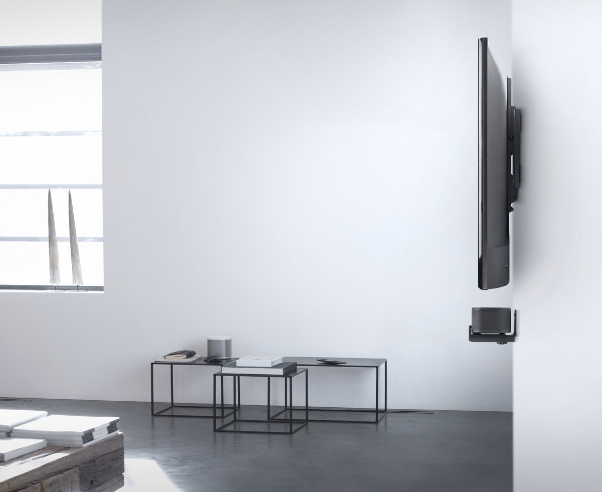 Ein modernes Wohnzimmer mit einem an der Wand befestigten Fernseher und Beistelltischen.