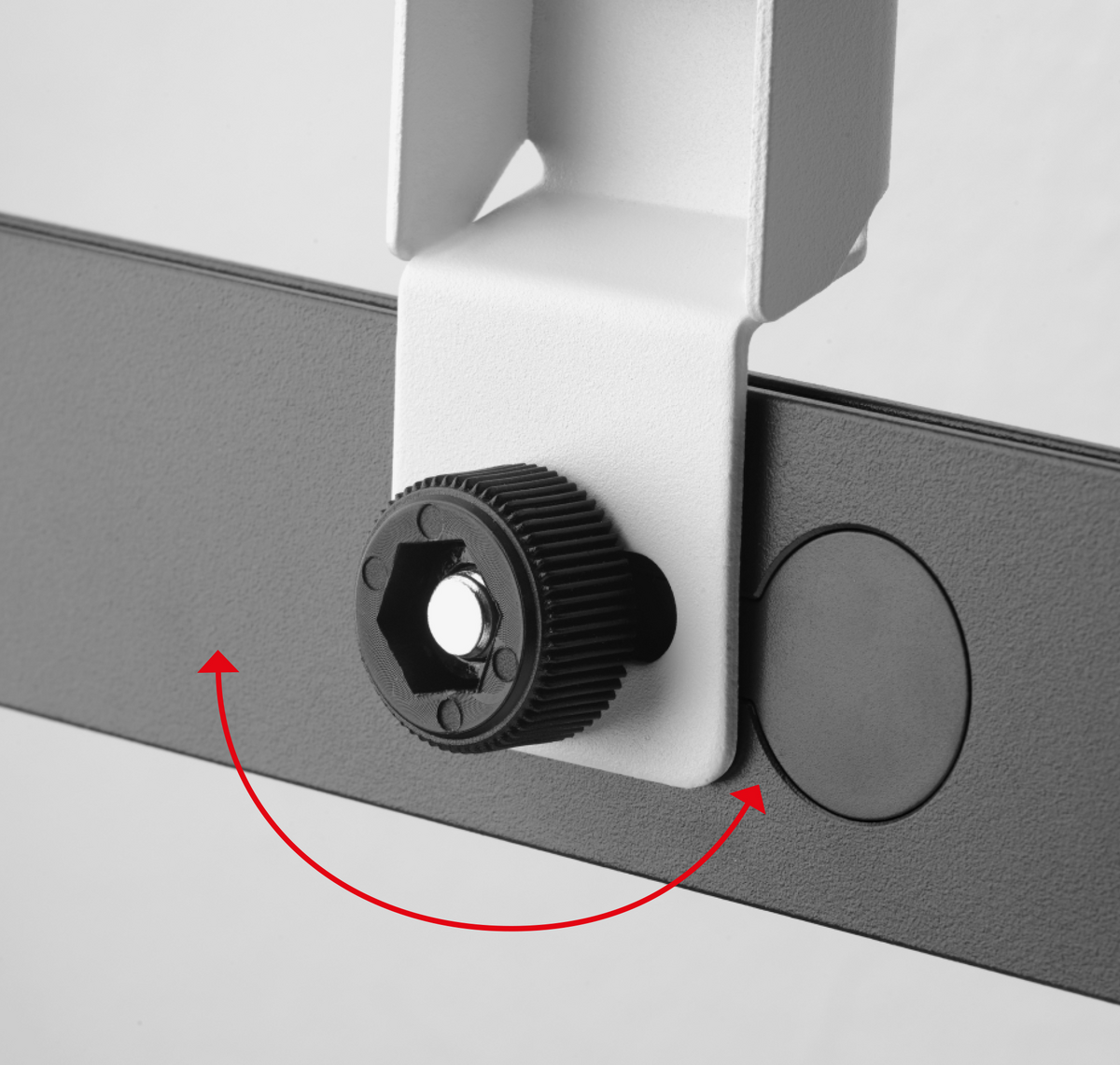 Eine weiße Halterung mit schwarzem Knopf und grauer Schiene, mit roten Pfeilen.