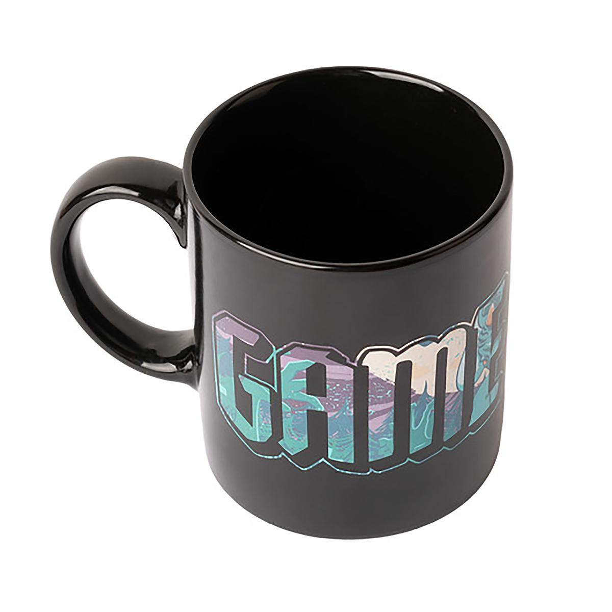 Schwarze Tasse mit dem Wort 'GAME' in farbenfrohen, stilisierten Buchstaben. Weißer Hintergrund, Griff links.