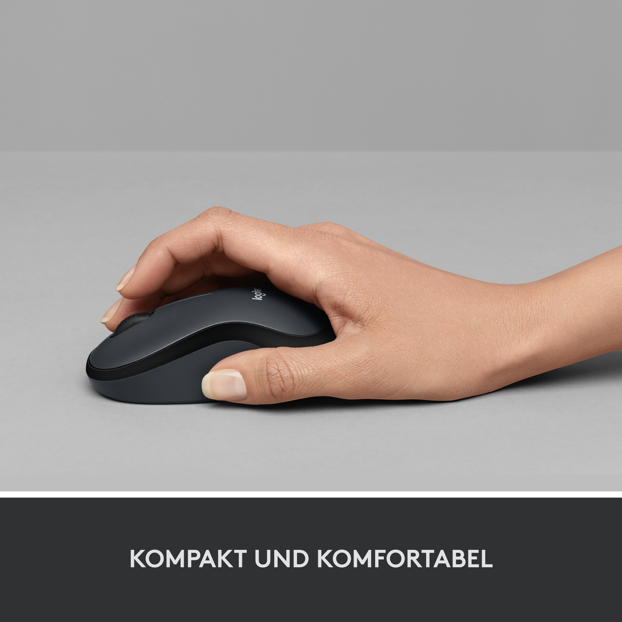 Hand benutzt eine schwarze kabellose Logitech-Maus auf grauer Oberfläche.