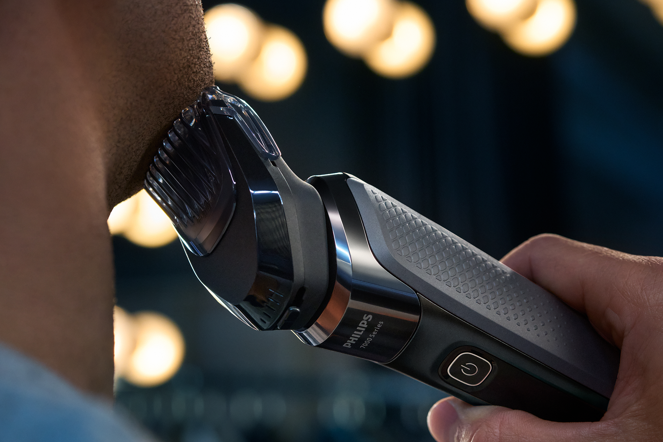 Man using a Philips 7000 series trimmer to shave his beard, close up.