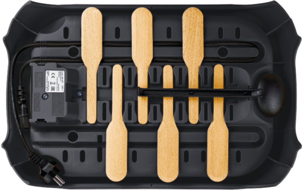 Zwarte ijsmachine met houten stokjes en elektrische componenten.