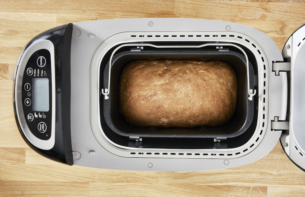 Bread maker with a loaf of bread inside, viewed from above.