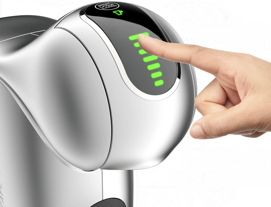 Een vinger die het aanraakscherm van een koffiemachine aanraakt.