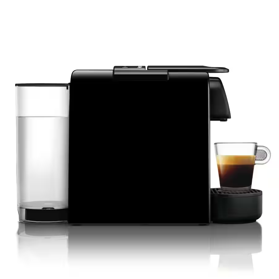 Schwarze Espressomaschine mit einem Glas Kaffee und einem Wasserbehälter auf weißer Oberfläche. Kaffee ist dunkel.