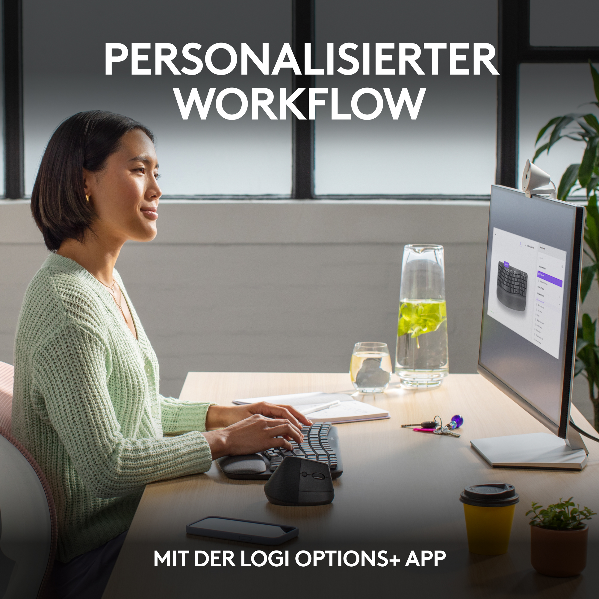 Frau arbeitet am Computer mit Tastatur und Telefon.