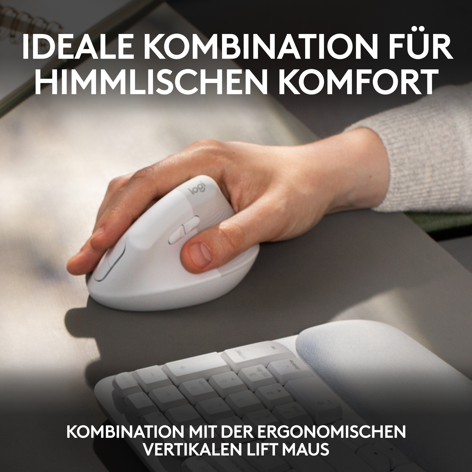 Die Hand einer Person, die eine weiße ergonomische Maus auf einer grauen Oberfläche benutzt, mit Text darüber und einer Tastatur darunter.