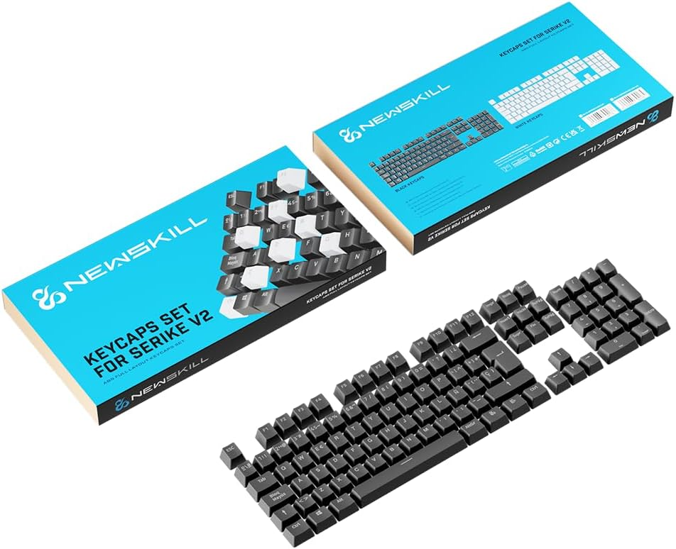 Juego de teclas de teclado, con teclas negras y cajas abiertas. El juego está sobre una superficie blanca.