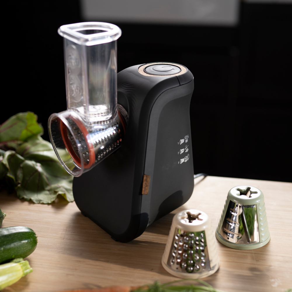 Un robot culinaire électrique avec un corps noir et trois lames interchangeables.