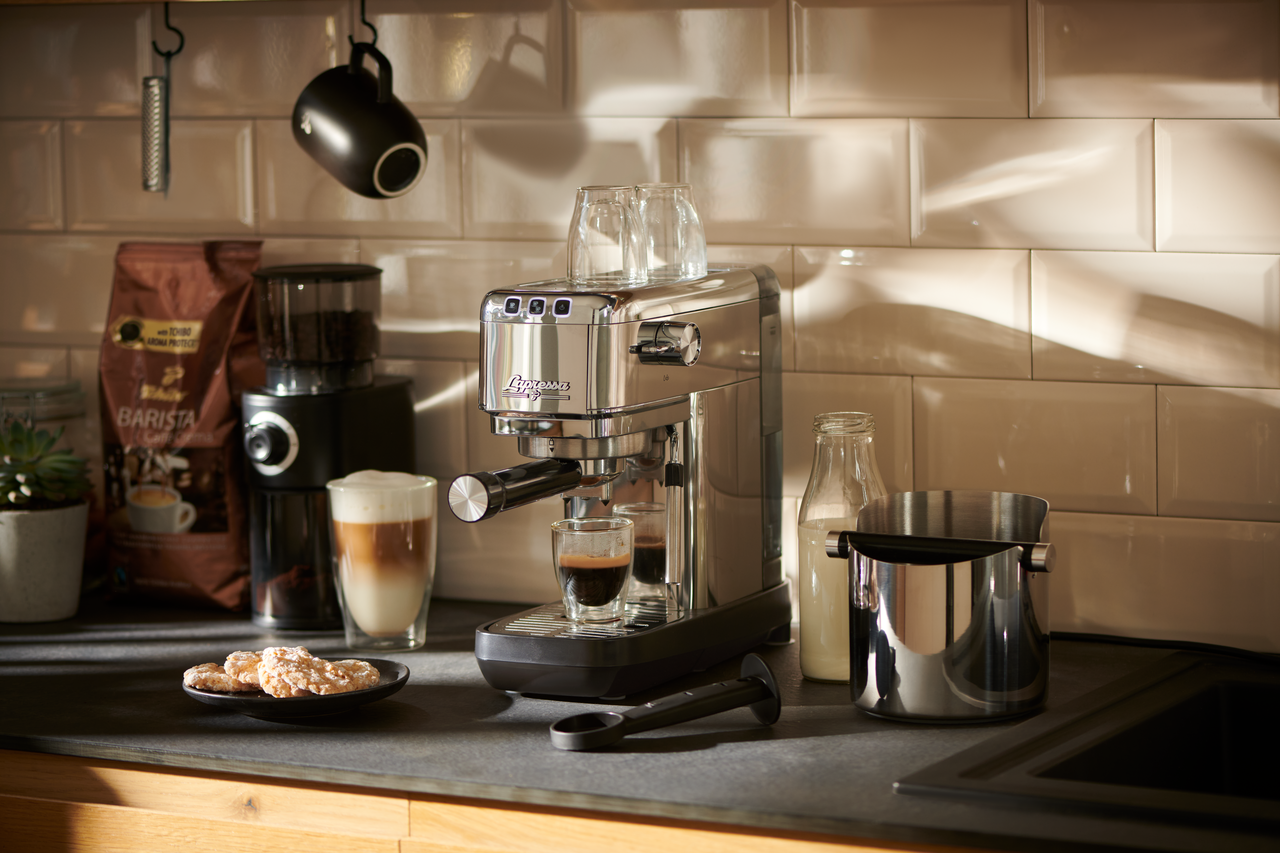 Mutfak tezgahında espresso makinesi, kahve yapım aksesuarları ve dekorasyonlarla.