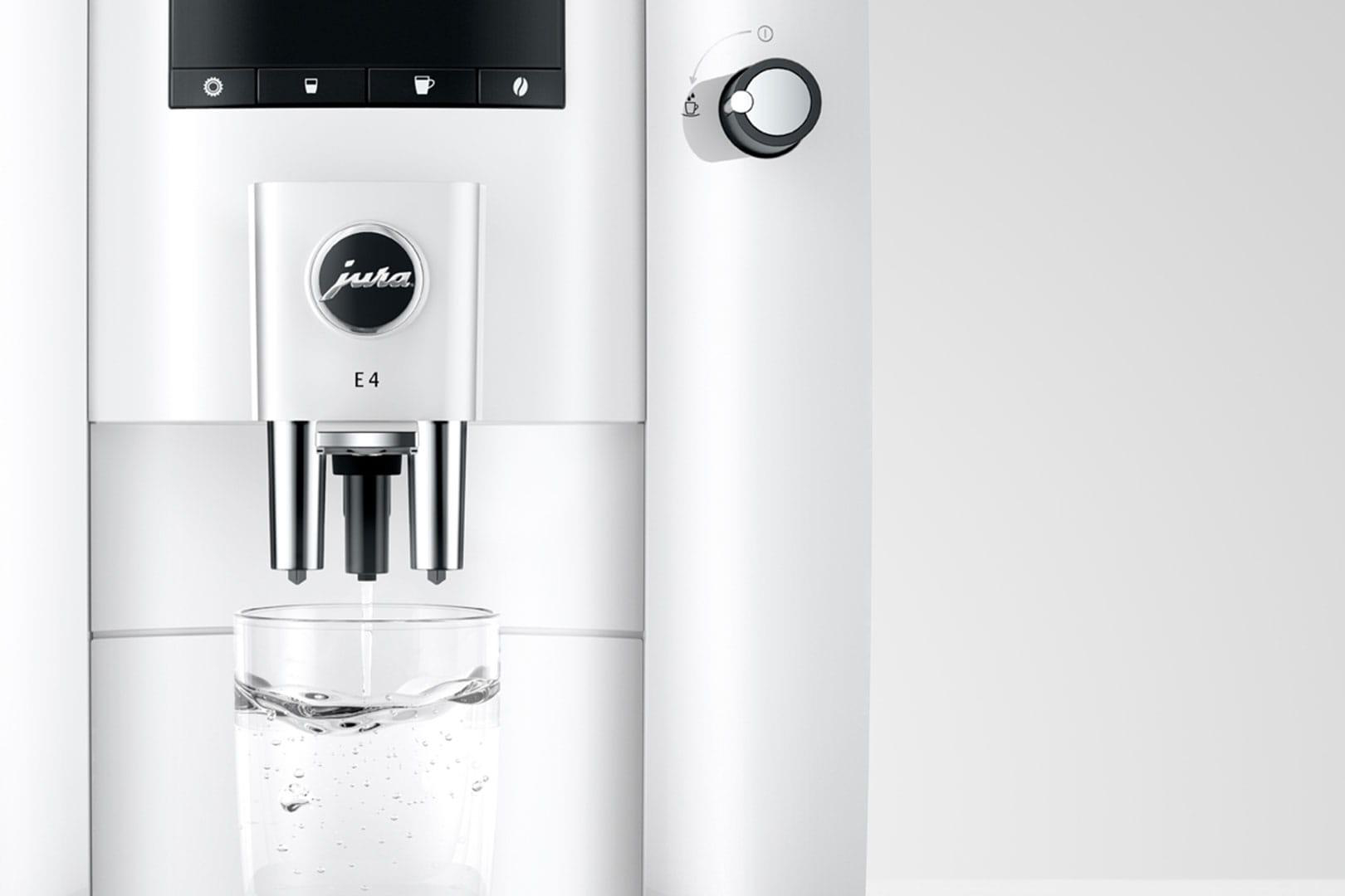 Eine weiße Kaffeemaschine, die Kaffee in ein Glas ausgibt.