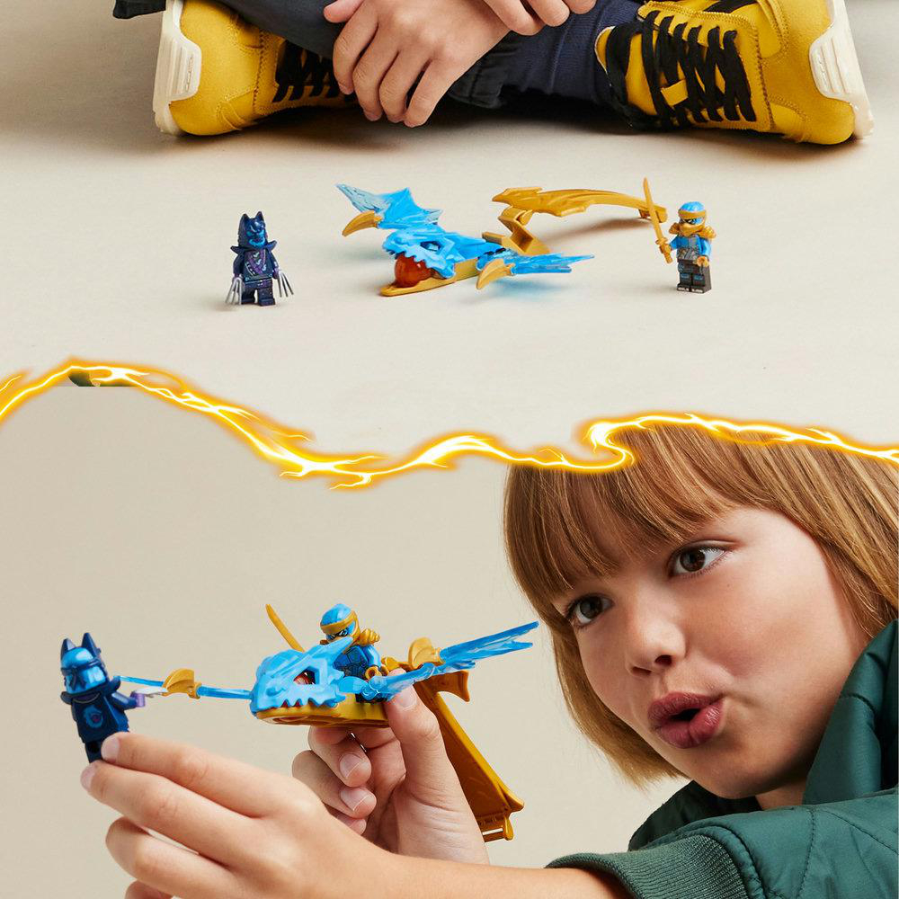 Ein Kind spielt mit Lego Ninjago Figuren und einem Drachen. Die Szene hat Blitzeffekte.