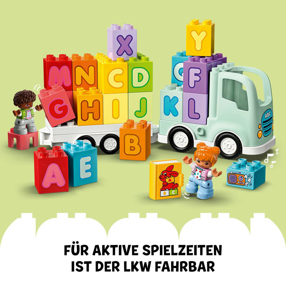 Ein Spielzeug-LKW mit Alphabetblöcken und Figuren. Bunte Blöcke und Figuren liegen um den LKW herum verstreut.