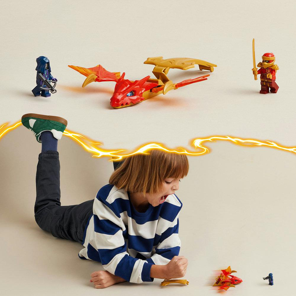 Junge spielt mit Lego Ninjago Set. Enthält Drachen, Figuren und Blitzeffekte.
