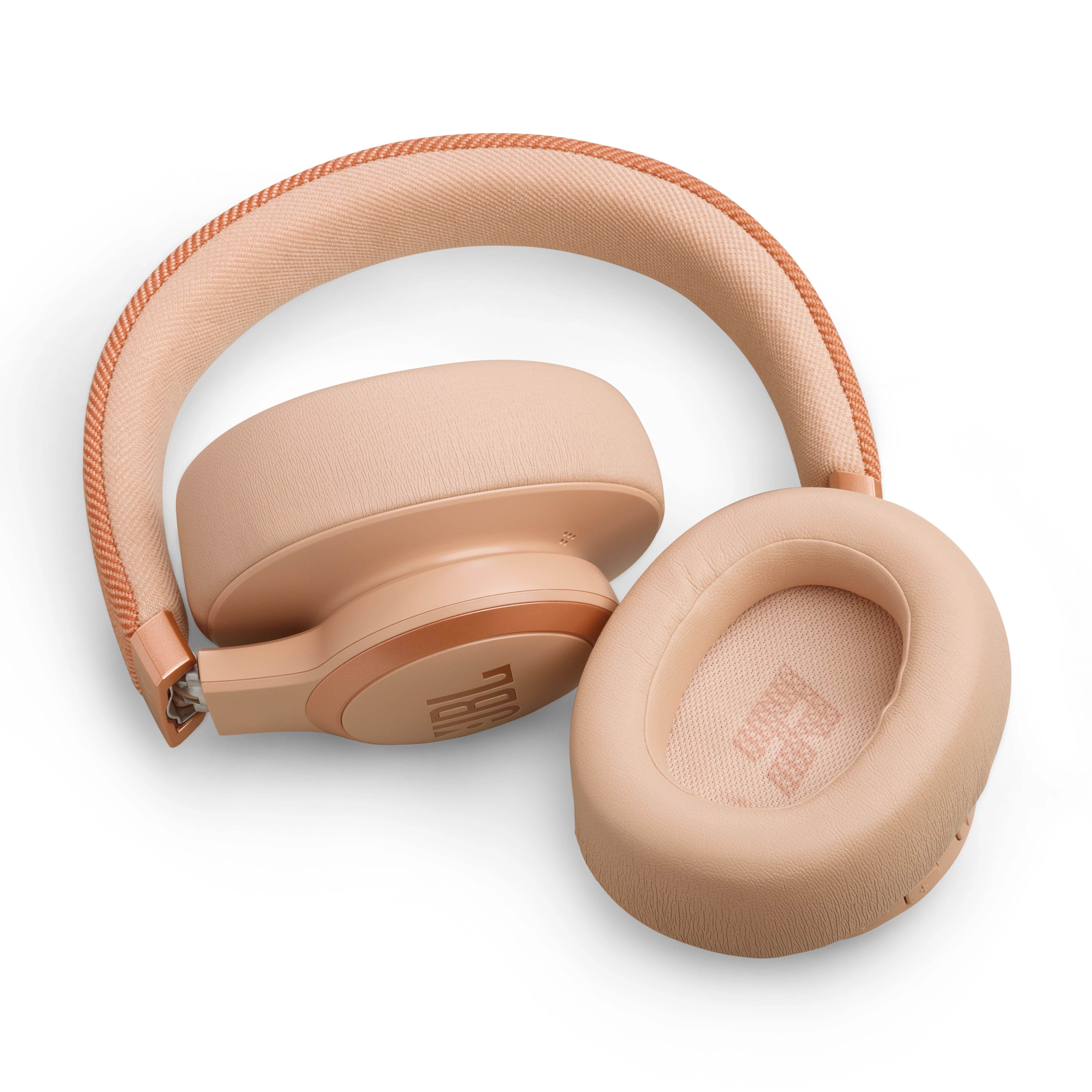 Beyaz bir yüzey üzerinde yatan bir çift açık pembe JBL kulaklık. Kafa bandı kemerli ve kulaklıklar açık.