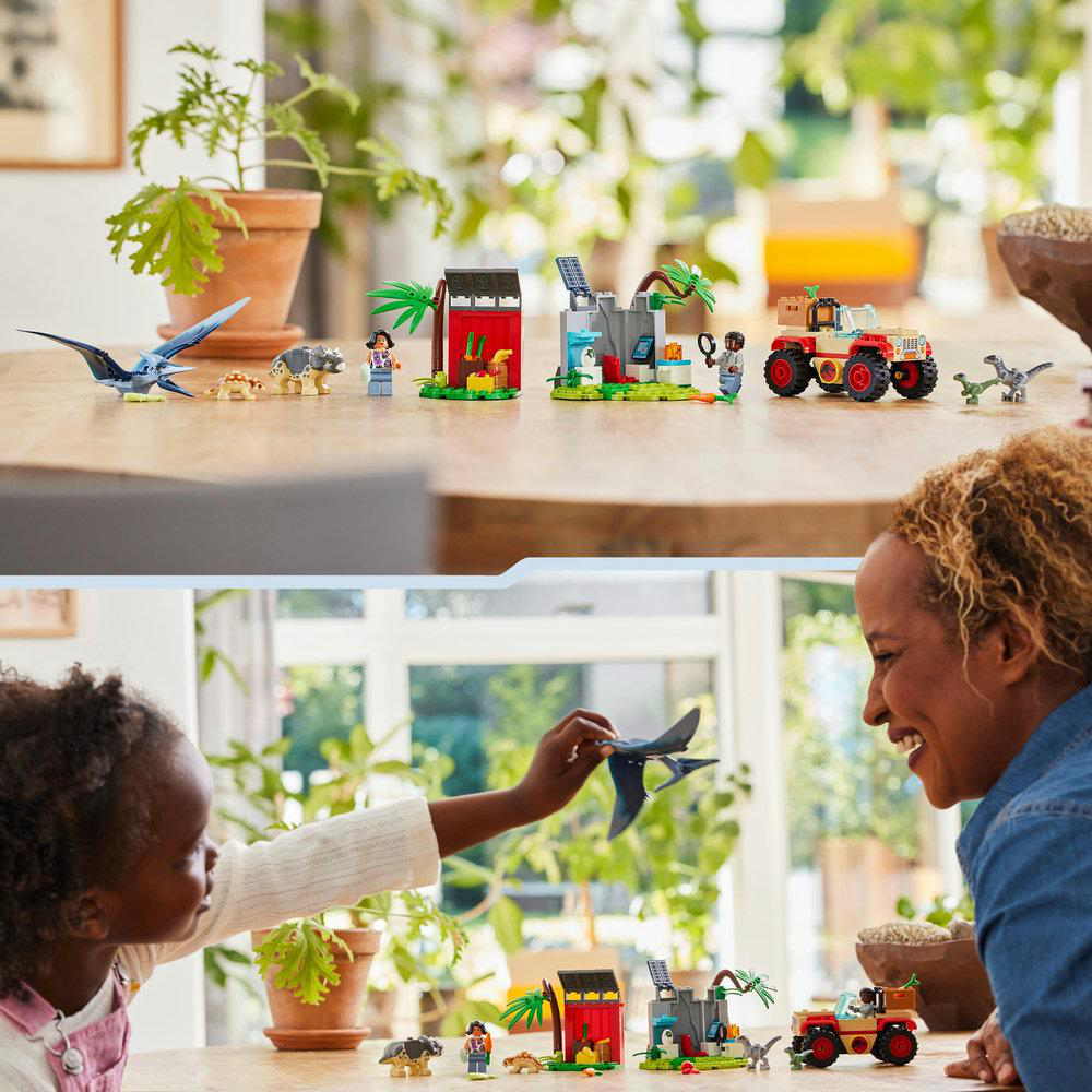 Lego-Set mit Dinosauriern, Figuren und einem Kind und Erwachsenen, die interagieren, drinnen.