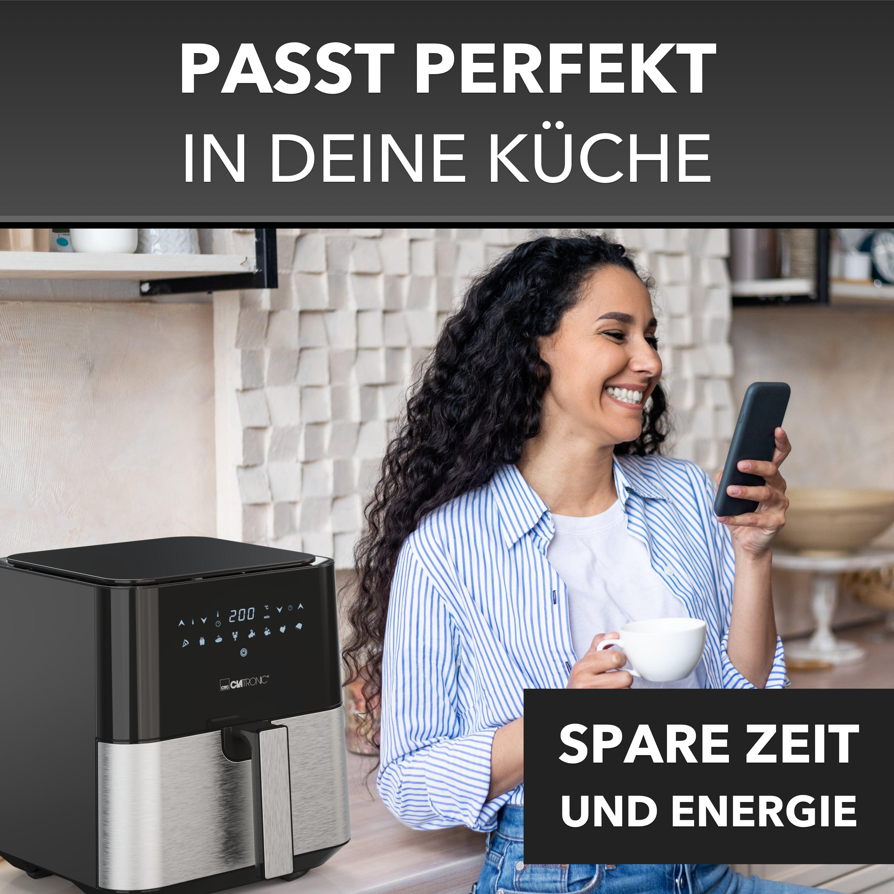 Frau mit Smartphone in der Nähe einer Heißluftfritteuse. Schwarze Heißluftfritteuse auf einer Theke. Text: Zeit und Energie sparen.