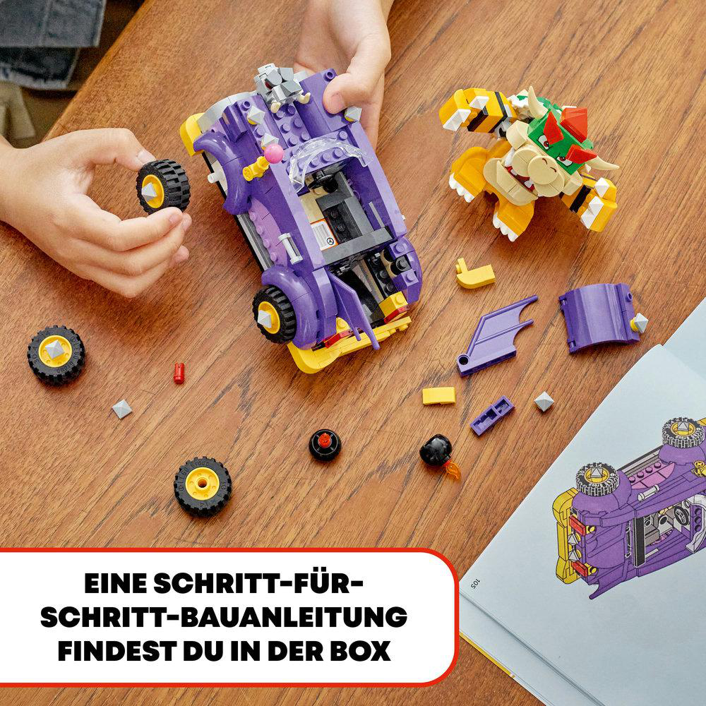 Ein Lego-Set mit einem lila Auto und Bowser-Figur. Anleitungen und Teile sind auf einem Tisch sichtbar.