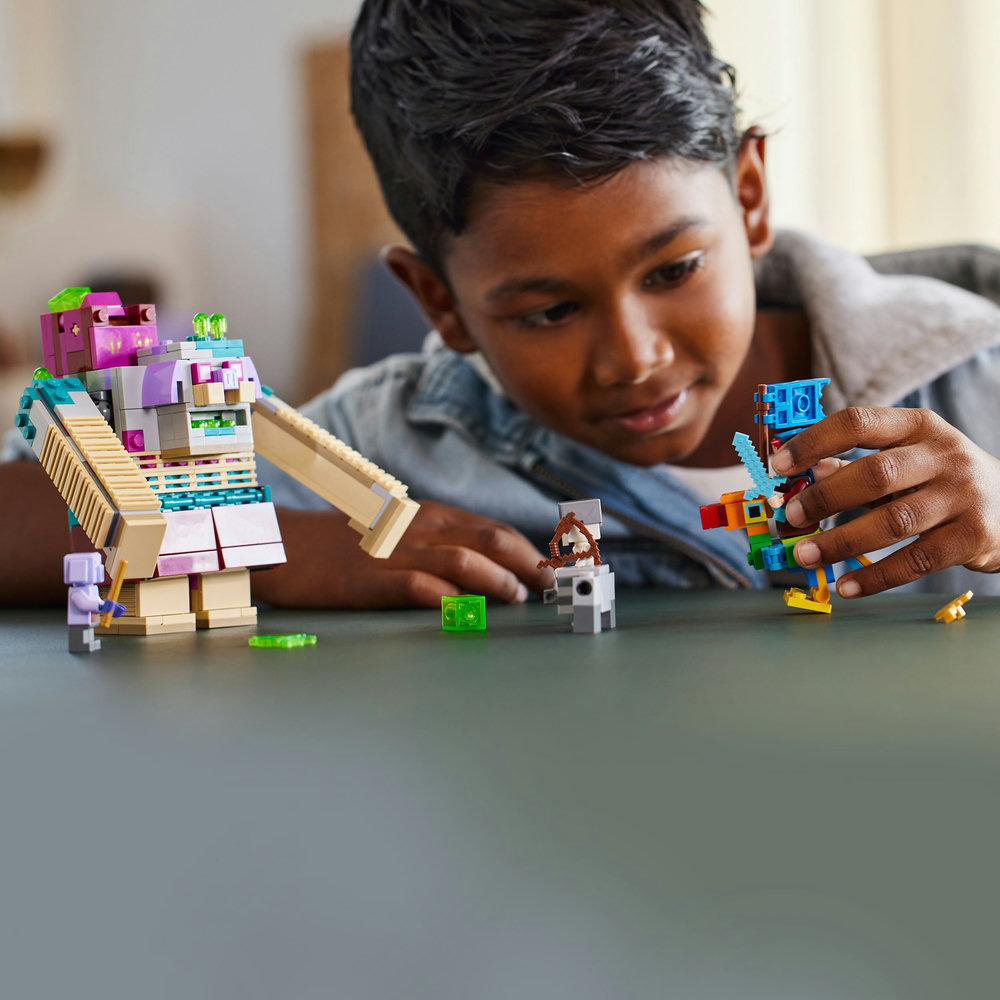 Ein Kind spielt mit Lego-Figuren. Verschiedenfarbige Lego-Figuren liegen auf einer grauen Oberfläche.