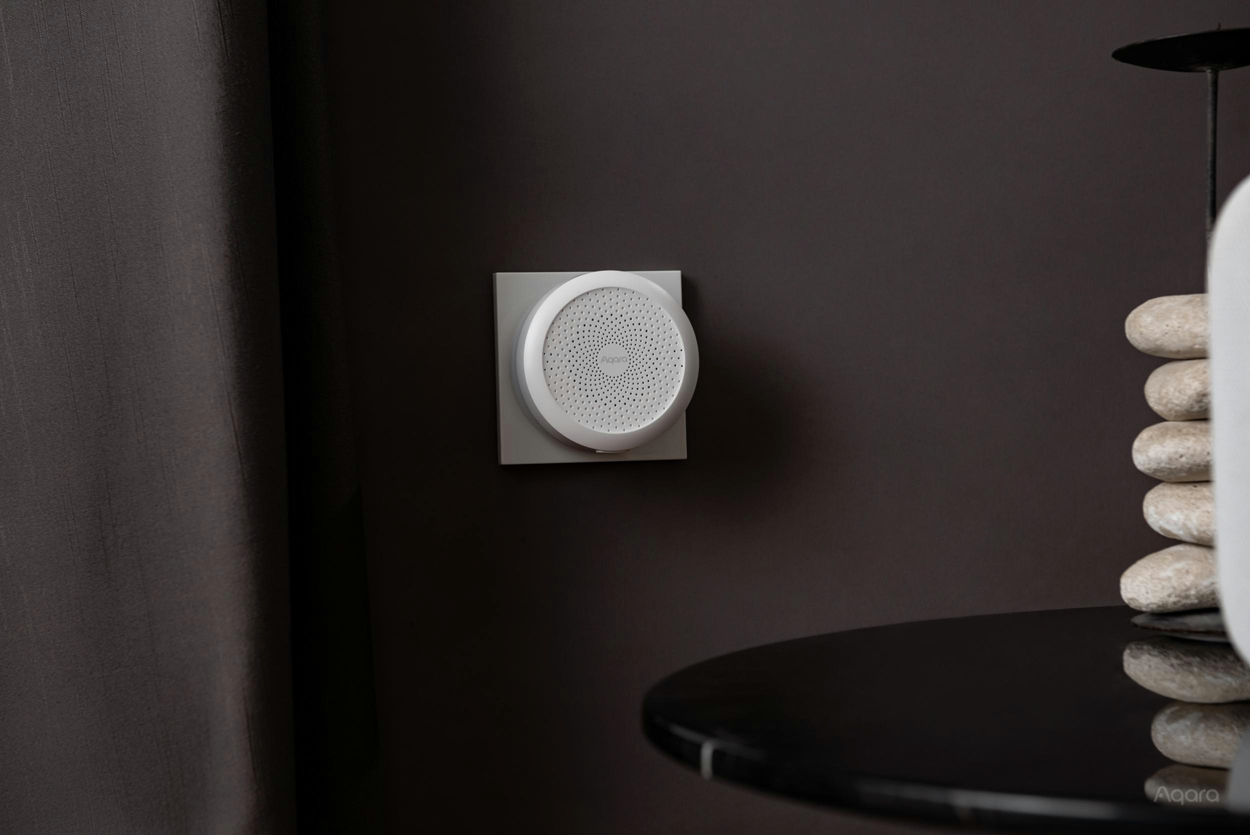 Smart-Home-Gerät an einer dunklen Wand montiert.