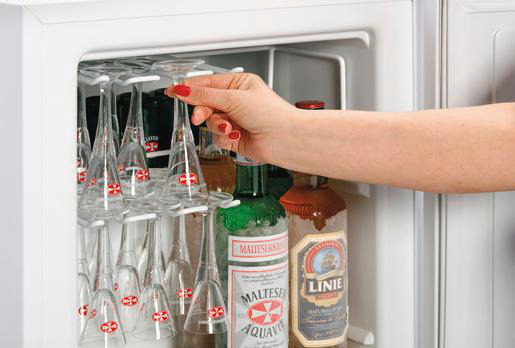 Eine Hand mit roten Nägeln nimmt ein Glas aus einem Kühlschrank. Im Kühlschrank befinden sich Gläser und Flaschen.