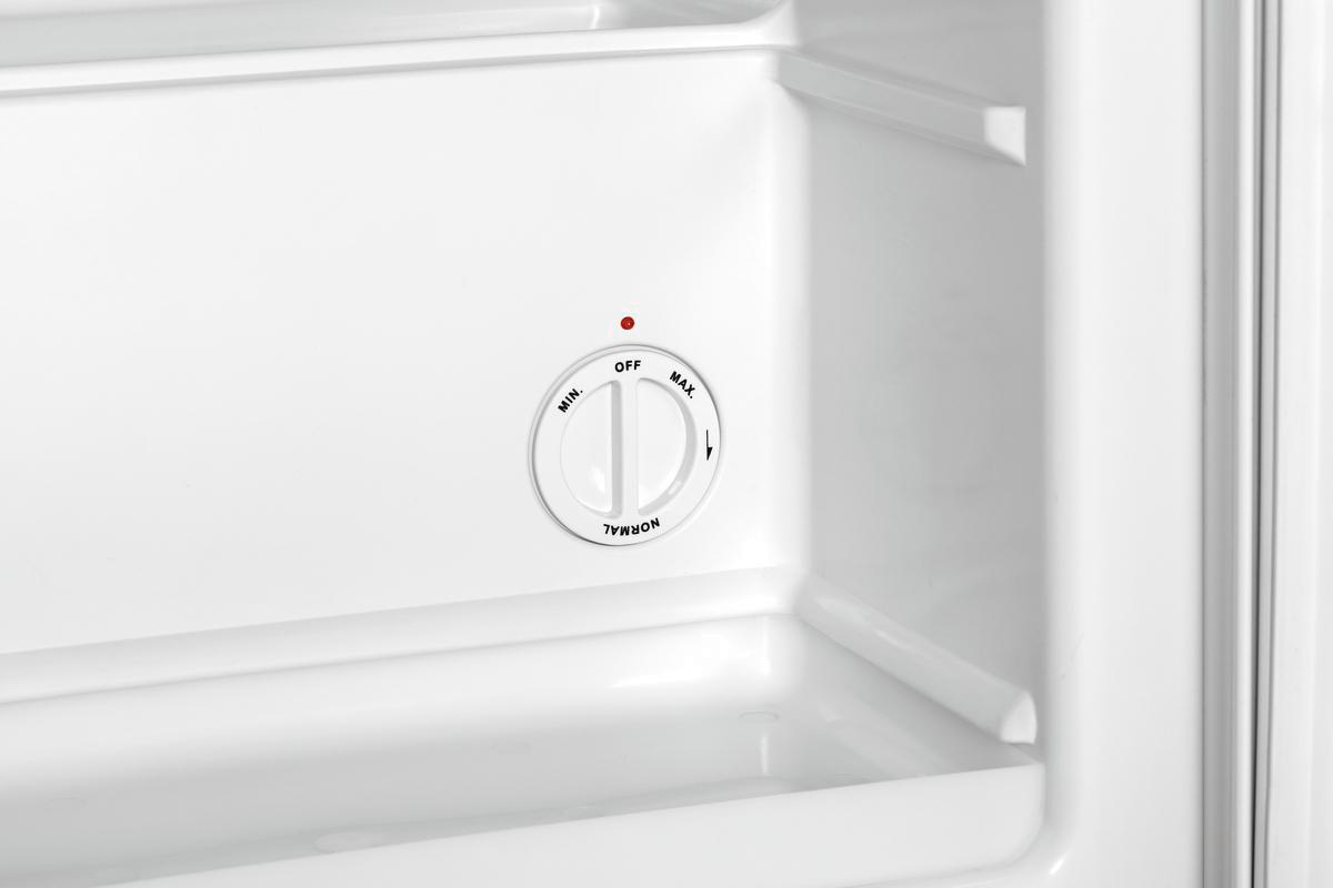 In einem weißen Kühlschrank zeigt ein Drehregler die Einstellungen an: aus, min, normal und max. Ein rotes Licht befindet sich über dem Drehregler.
