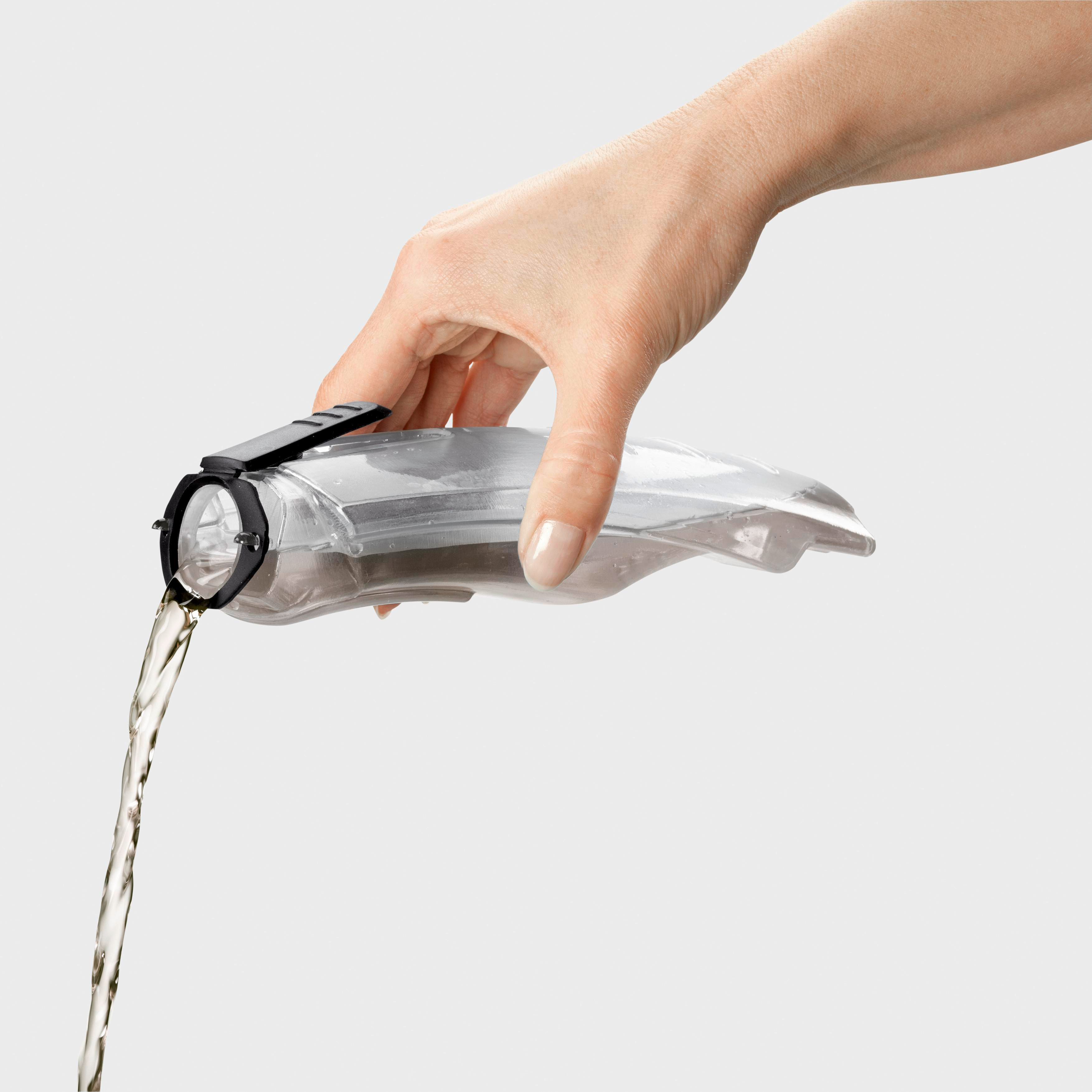 Eine Hand gießt Flüssigkeit aus einem transparenten Behälter. Weißer Hintergrund.
