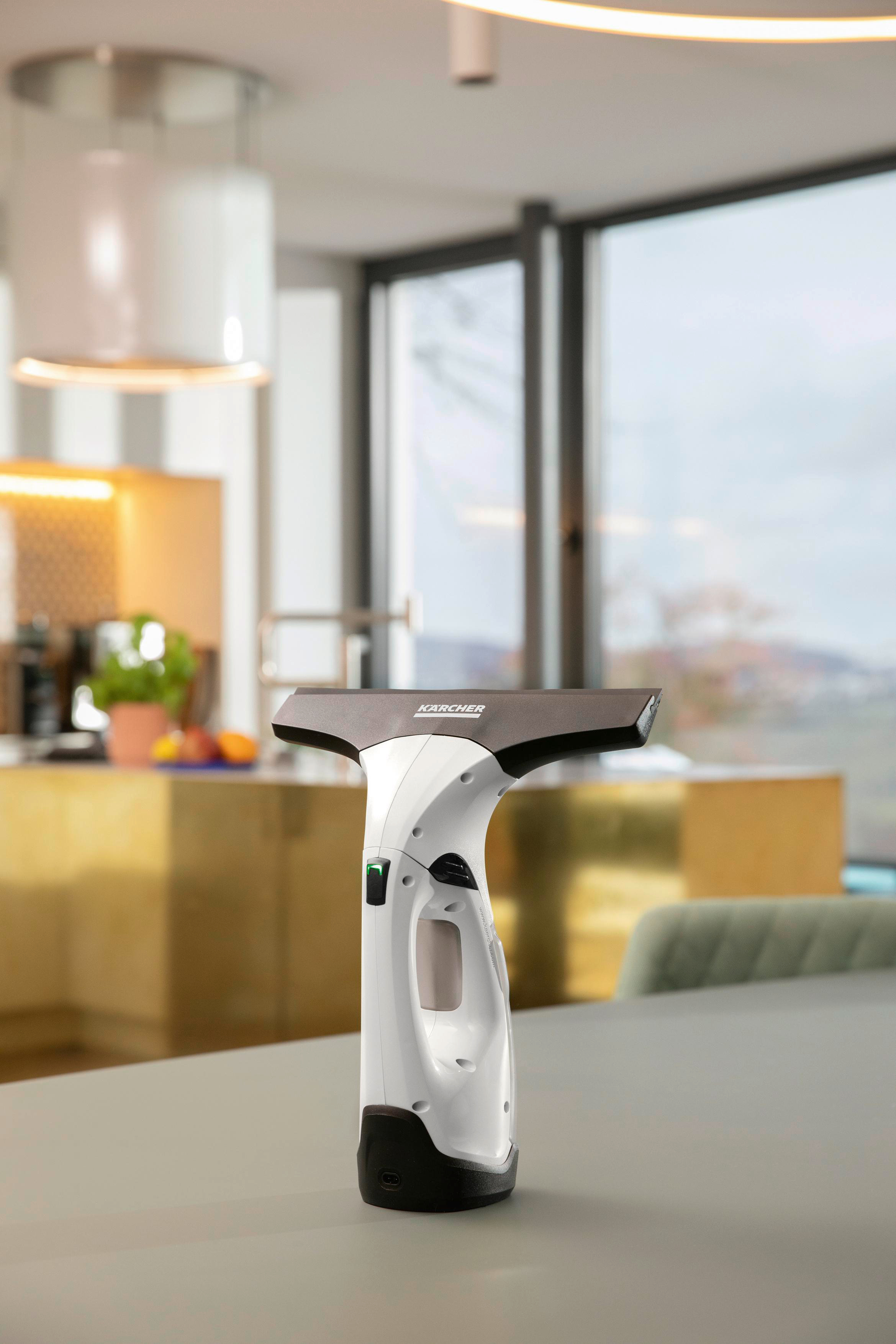 Ein weißer Fensterreiniger auf einem Tisch, in einer Küche mit einer Lampe.