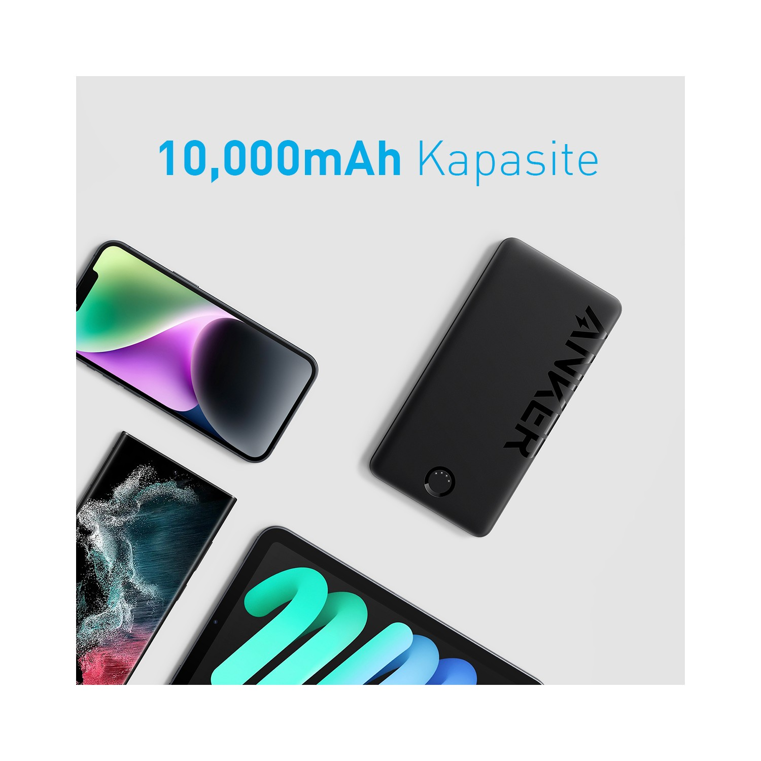 ANKER yazılı siyah powerbank, iki akıllı telefon ve bir tablet.