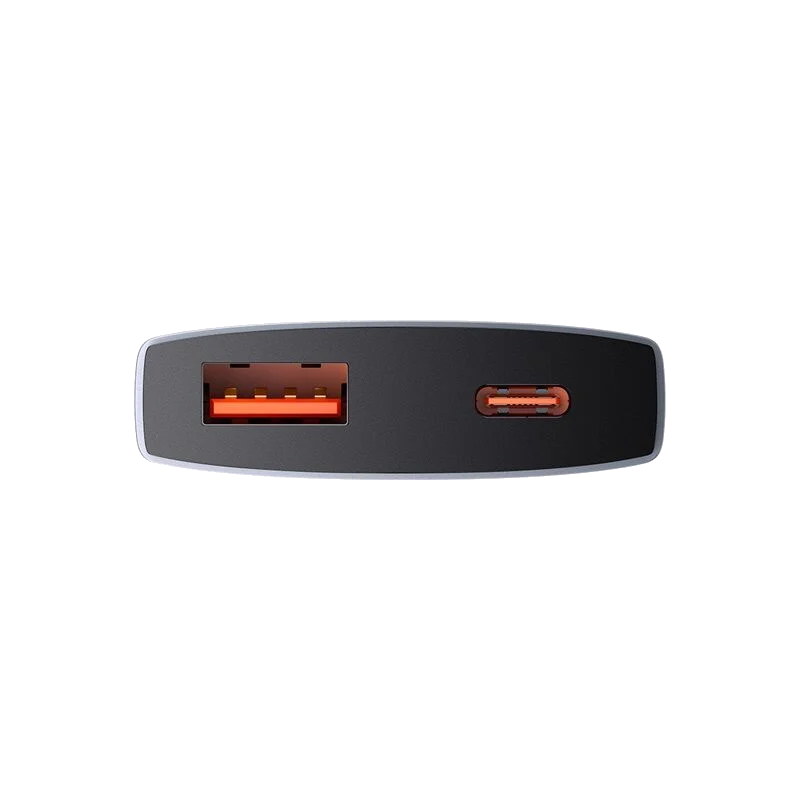 Turuncu USB ve USB-C bağlantı noktalarına sahip koyu gri bir güç bankasının yakın çekimi. Arka plan siyah.