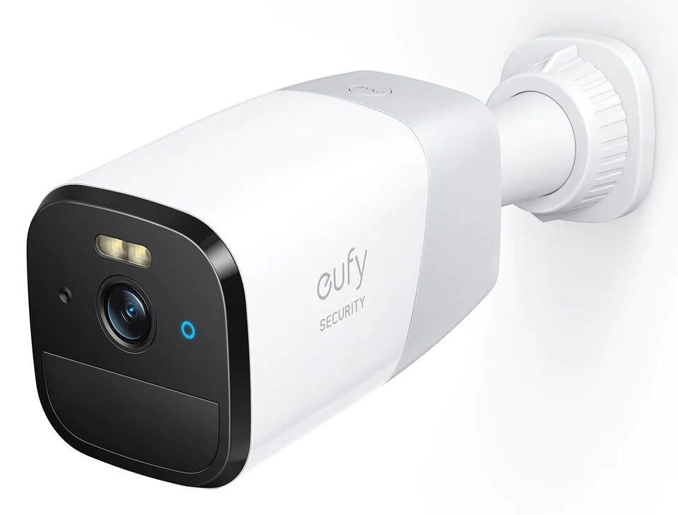 Biała kamera bezpieczeństwa zamontowana na białej ścianie, z czarnym przodem i niebieskim światłem.