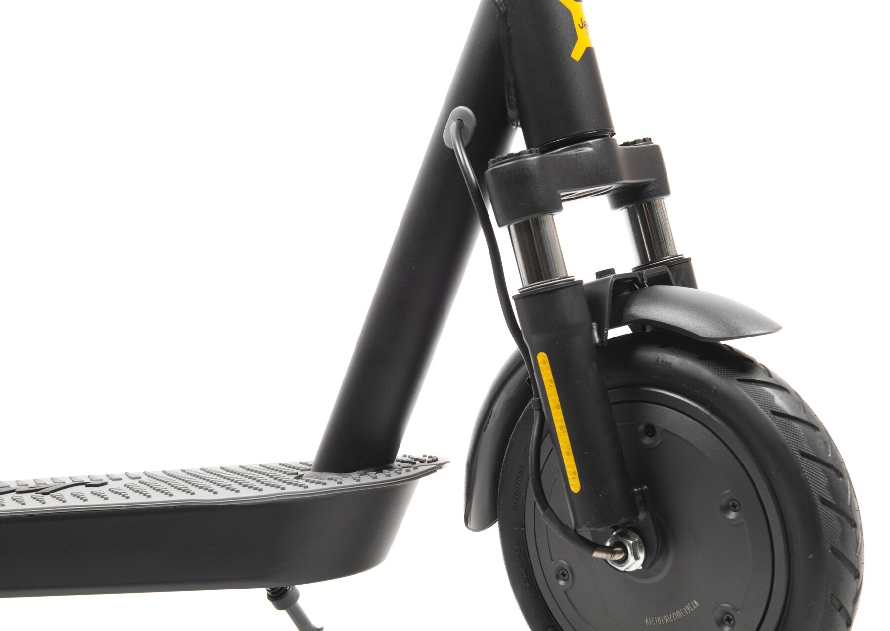 Zbliżenie przedniego koła i zawieszenia czarnej hulajnogi. Widoczna jest żółta naklejka.