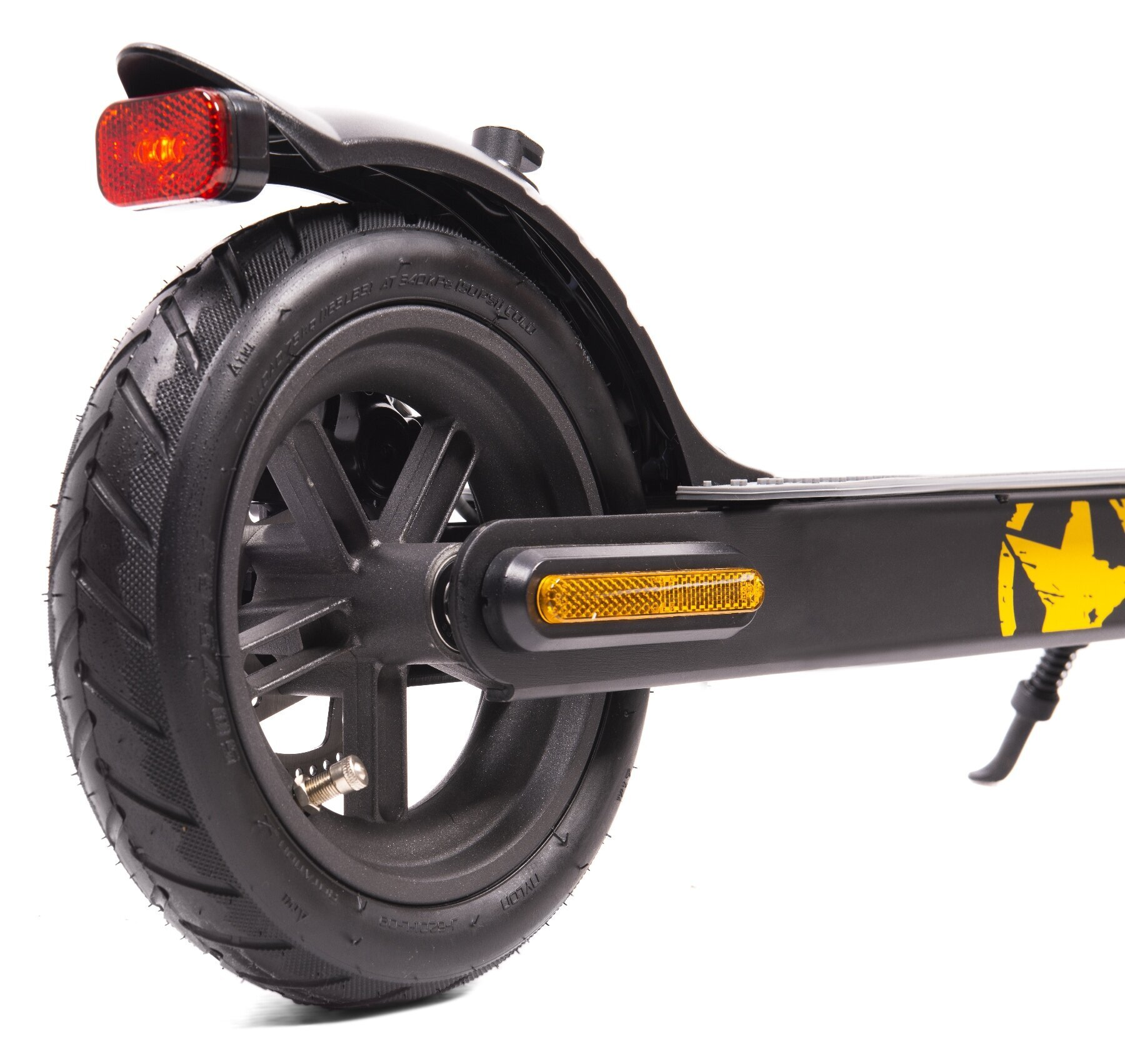 Zbliżenie na tylne koło czarnej hulajnogi elektrycznej z czerwonym odblaskiem.