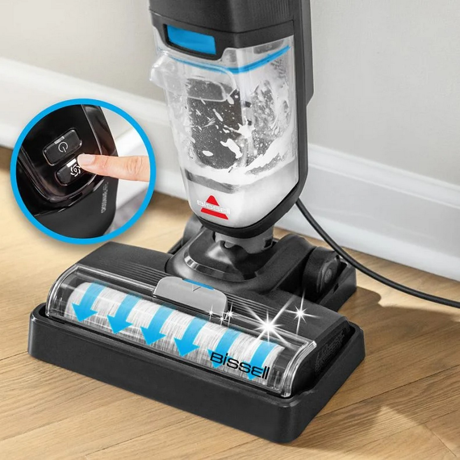 Aspirateur Bissell noir et blanc, avec la main d'une personne appuyant sur un bouton.