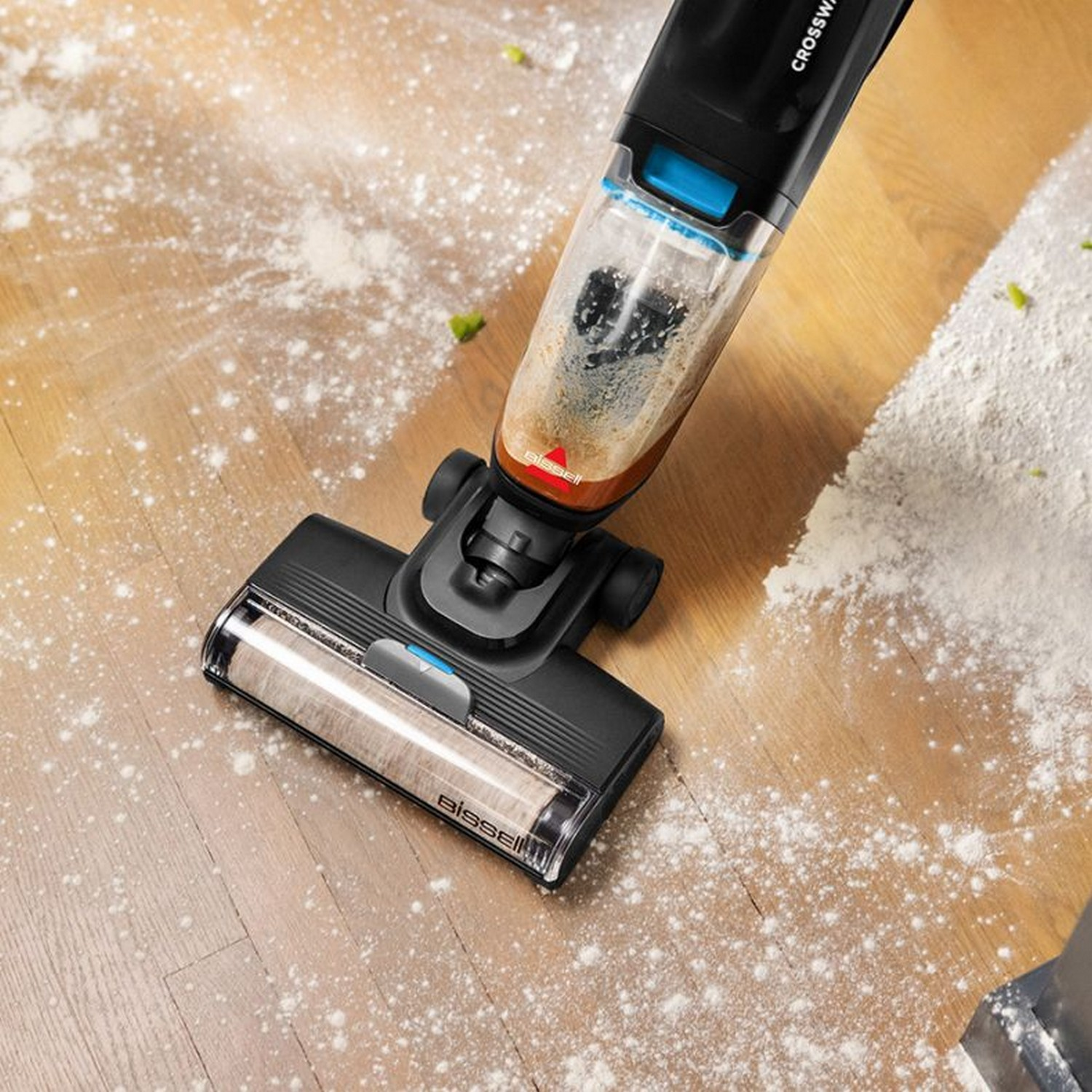 Aspirateur nettoyant un sol en bois avec de la farine. Gros plan.