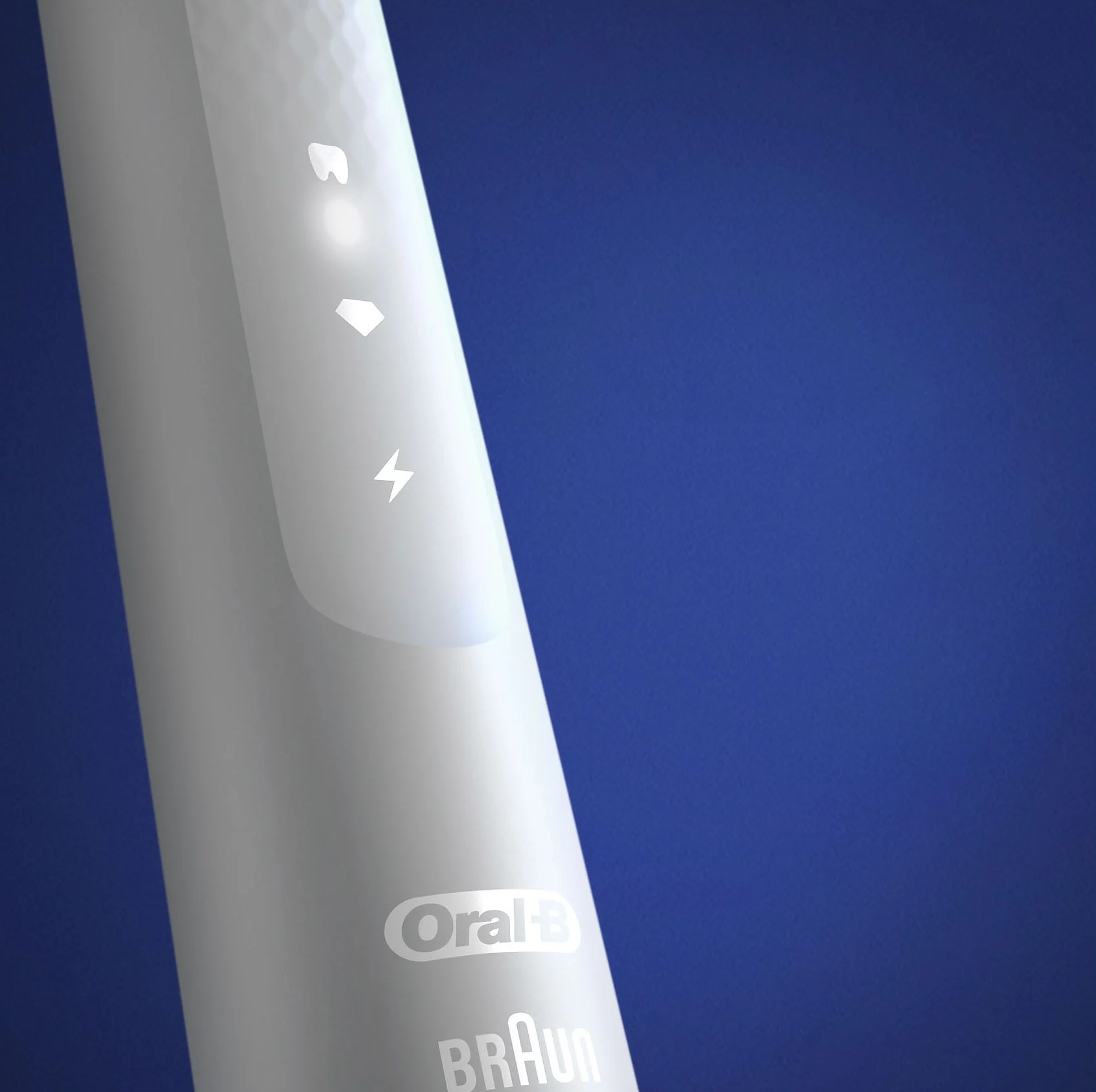 Elektromos fogkefe közelképe. Oral-B Braun márka, kék háttér előtt.