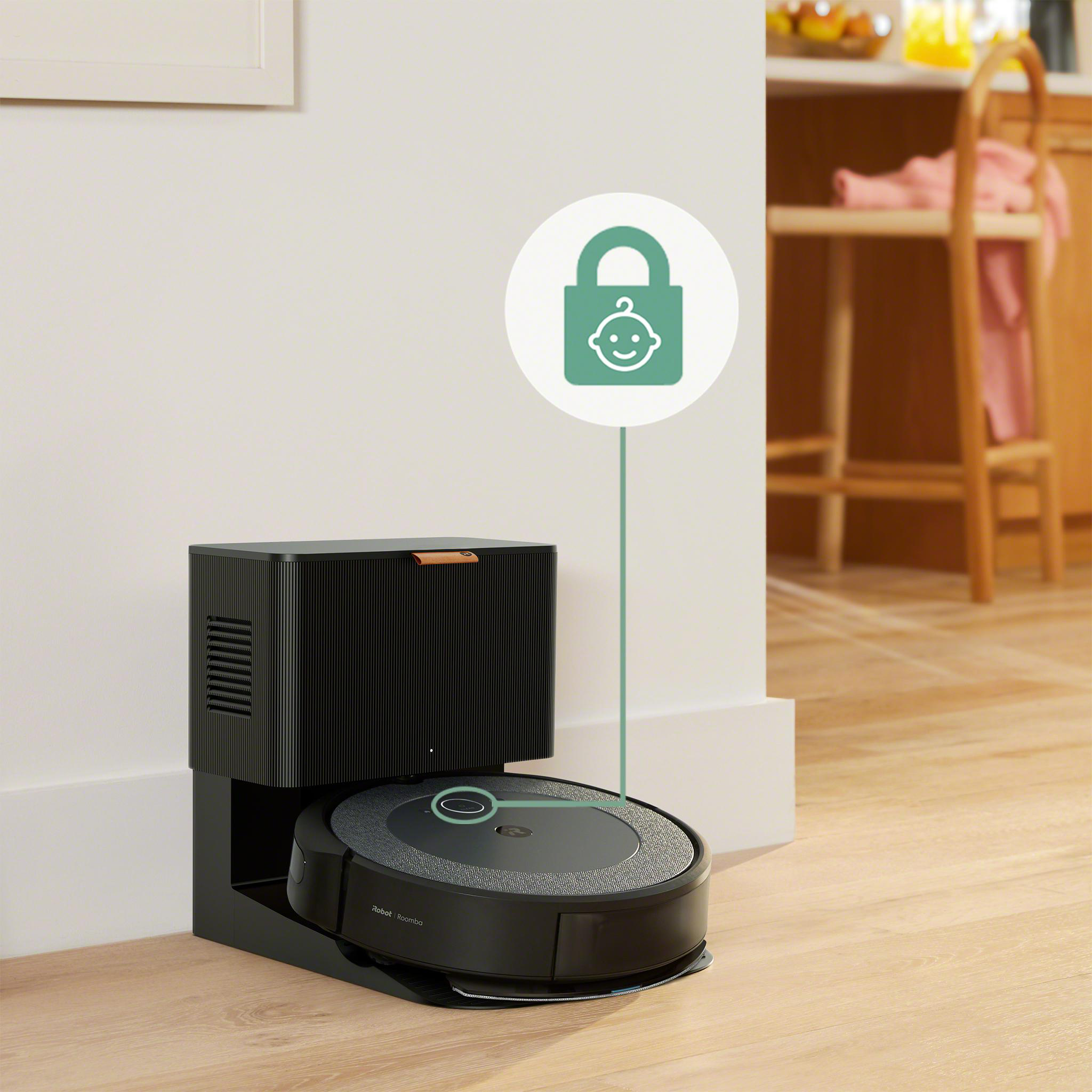 Schwarzer Roomba-Staubsauger in der Dockingstation, Babyschloss-Symbol. Holzboden, weiße Wand und Küchenhintergrund.