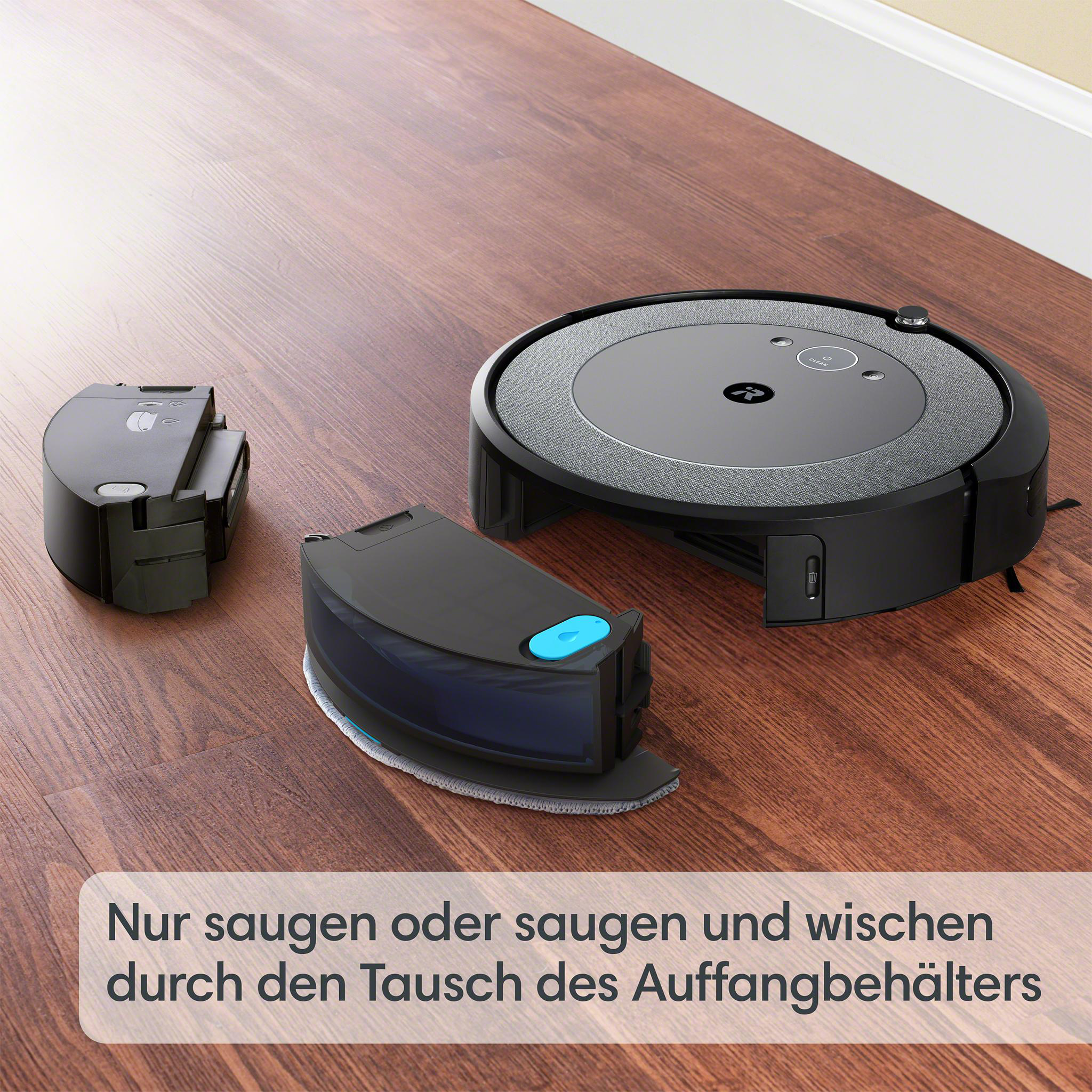 Ein schwarzer Roboterstaubsauger, ein Wassertank und eine Ladestation stehen auf einem Holzboden. Der Staubsauger ist rund.