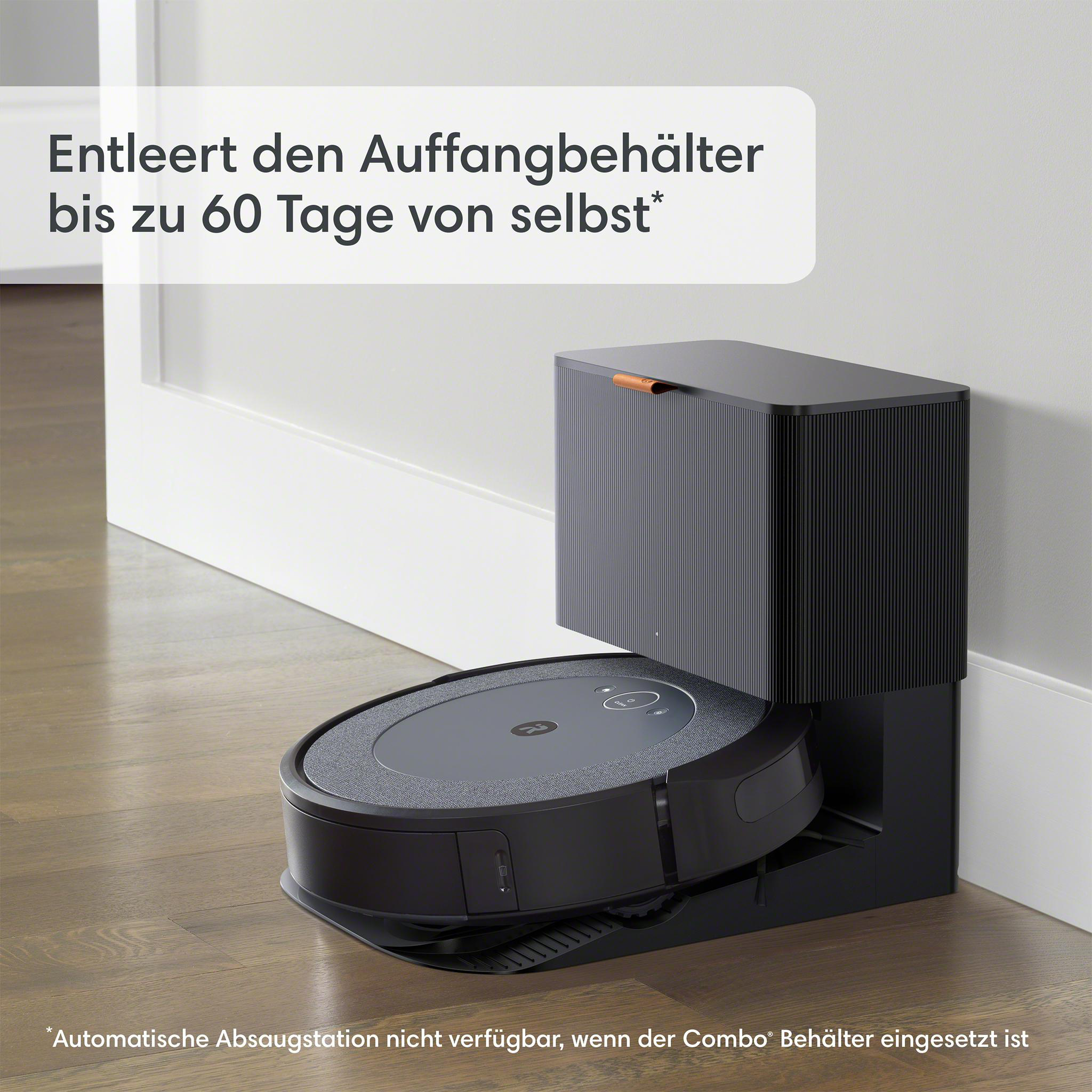 Ein schwarzer Roboter-Staubsauger in einer grauen Ladestation auf einem Holzboden neben einer weißen Wand.
