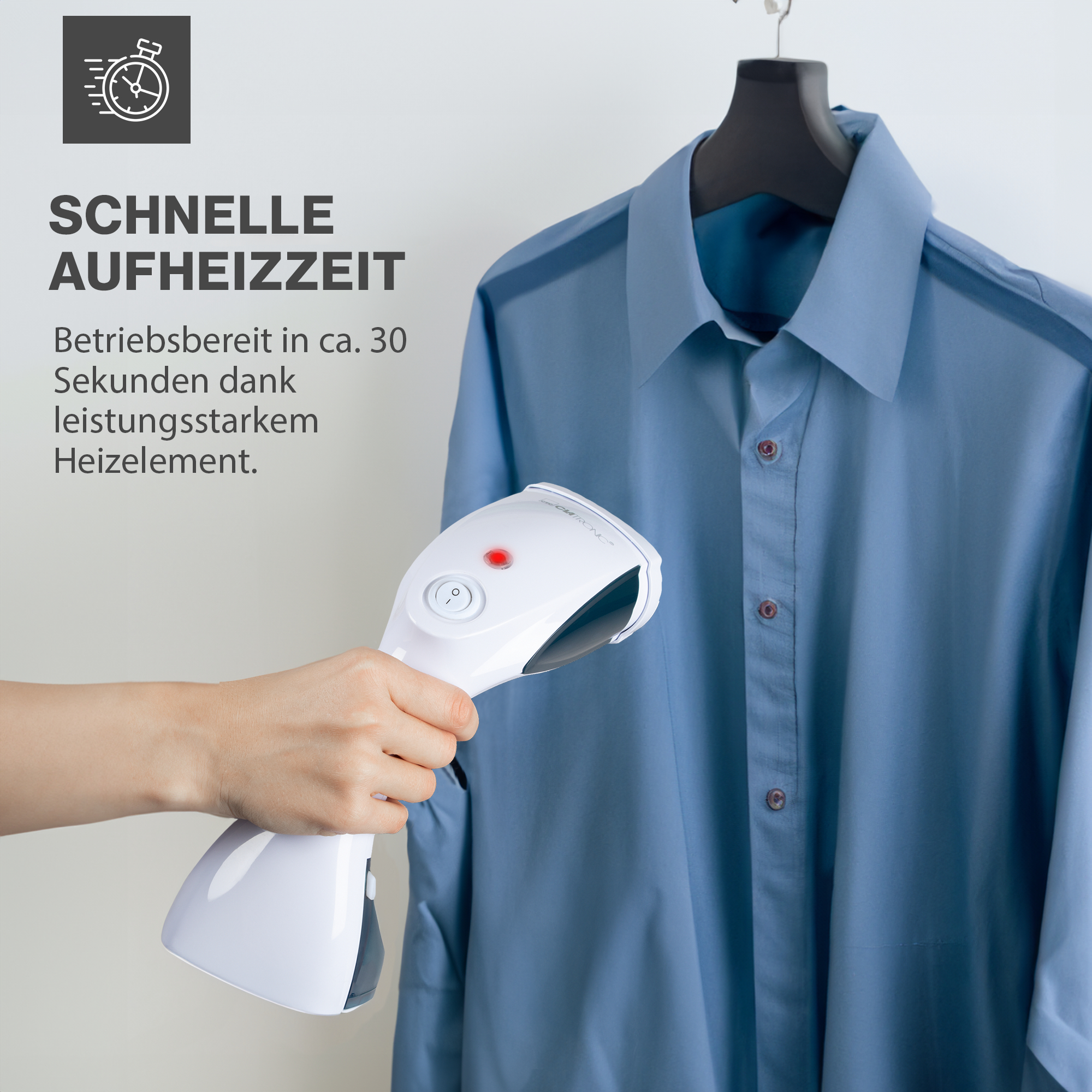 Handdampfer bügelt ein blaues Hemd, das auf einem schwarzen Kleiderbügel hängt.