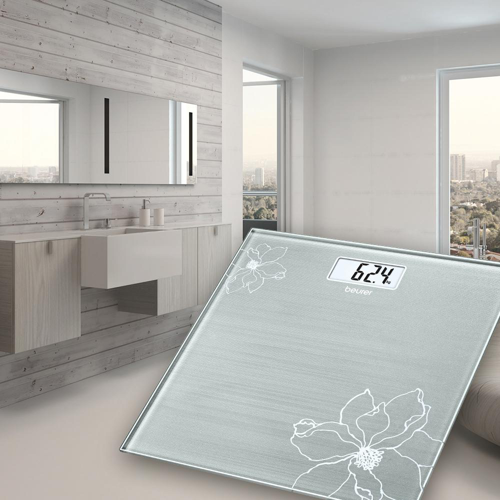 Badezimmer mit einer Digitalwaage auf dem Boden. Im Hintergrund ein Spiegel und ein Waschbecken.