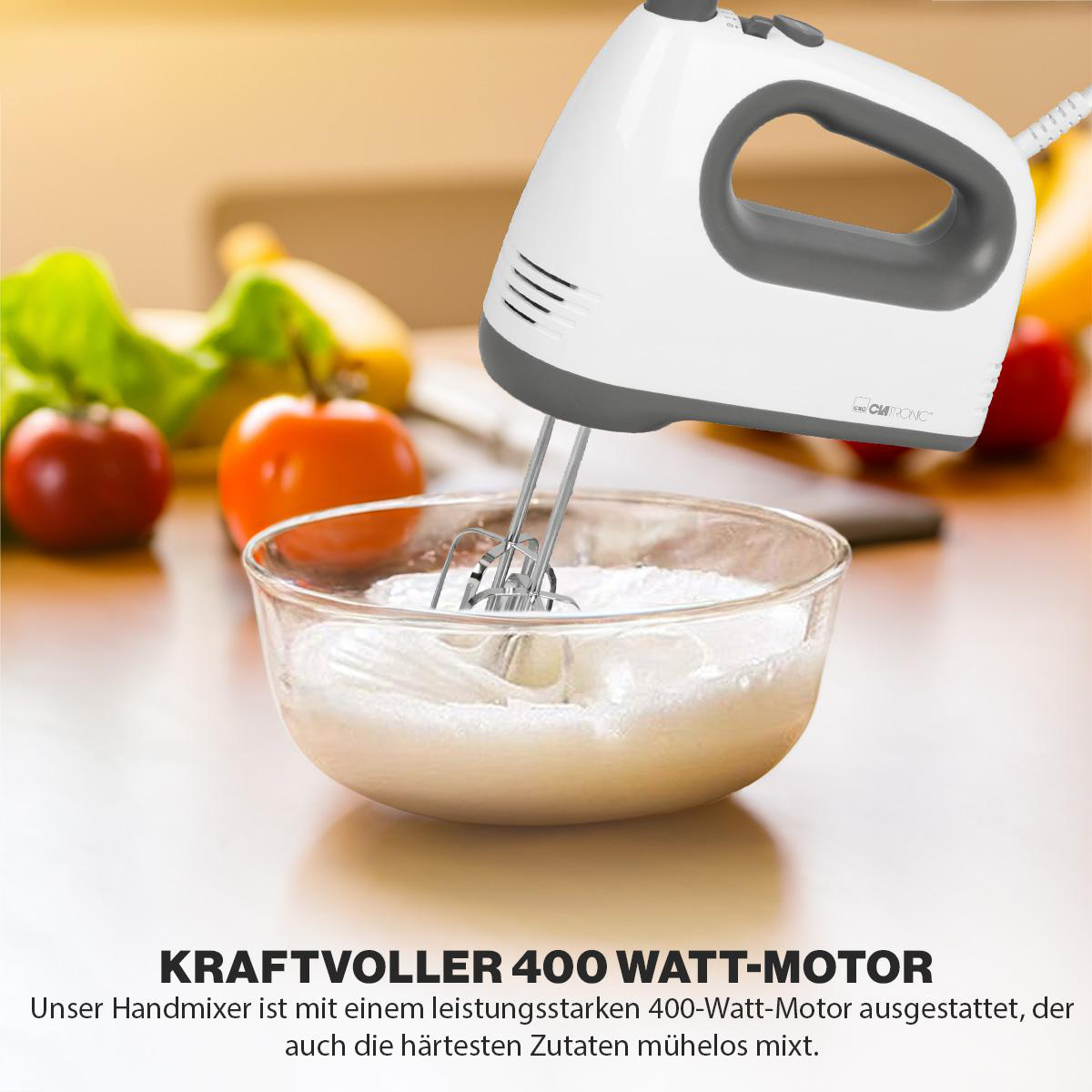 Weißer und grauer Handmixer, der Zutaten in einer Glasschüssel verrührt.