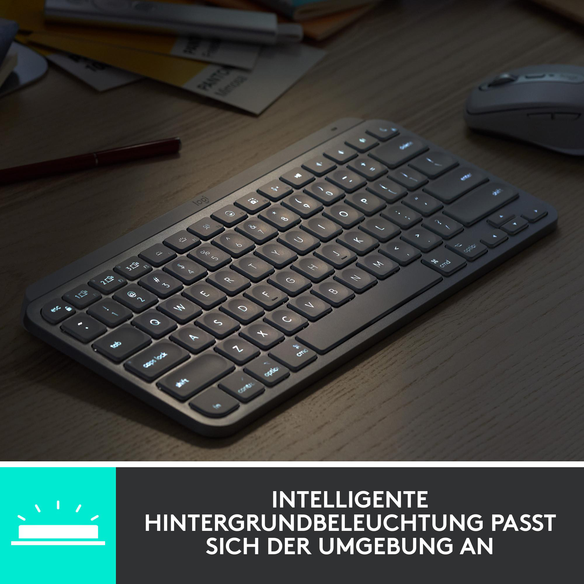 Eine schwarze, kabellose Tastatur mit beleuchteten Tasten auf einem Holztisch. Eine Maus und Papiere sind im Hintergrund.