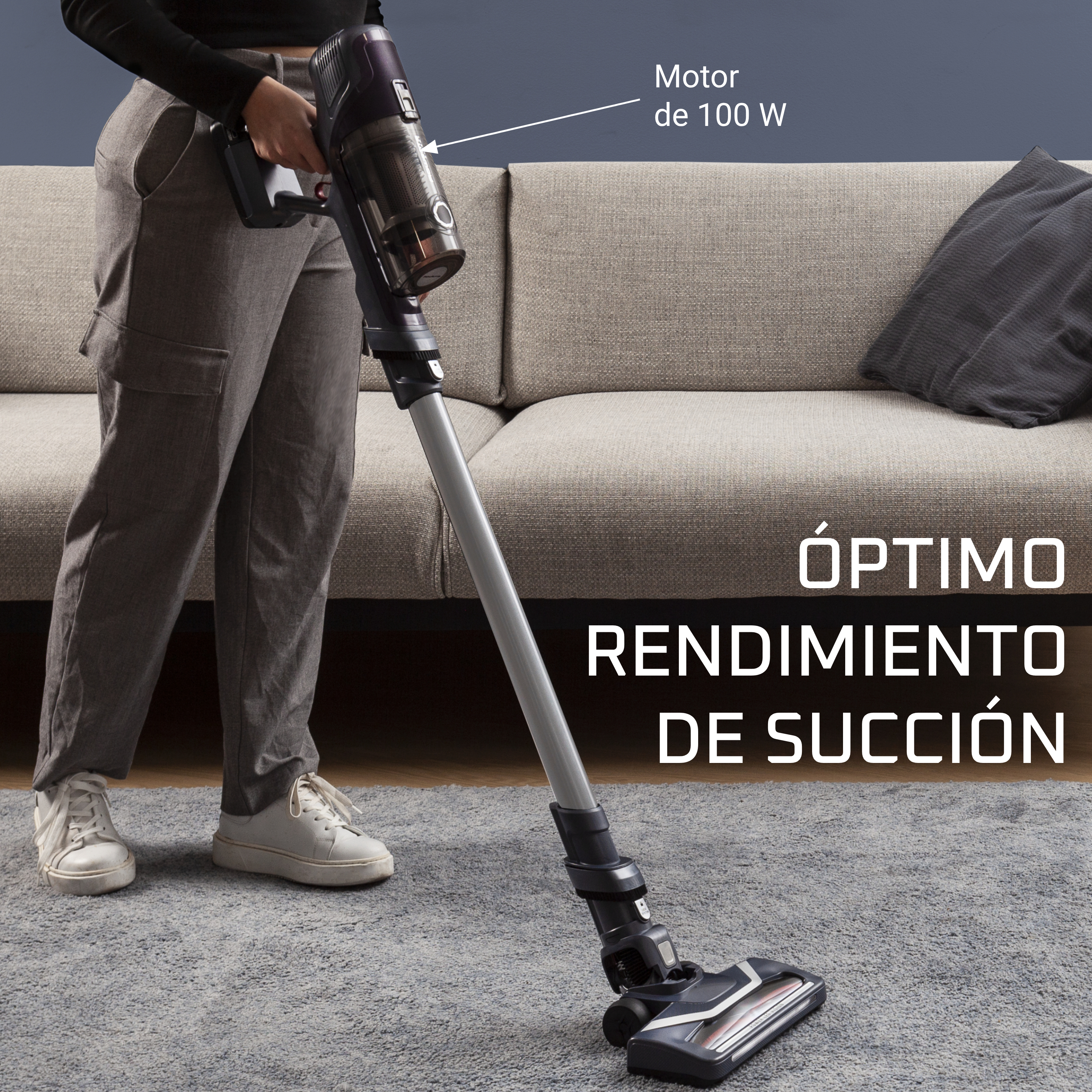 Persona aspirando una alfombra gris con una aspiradora. Texto: 'ÓPTIMO RENDIMIENTO DE SUCCIÓN'.