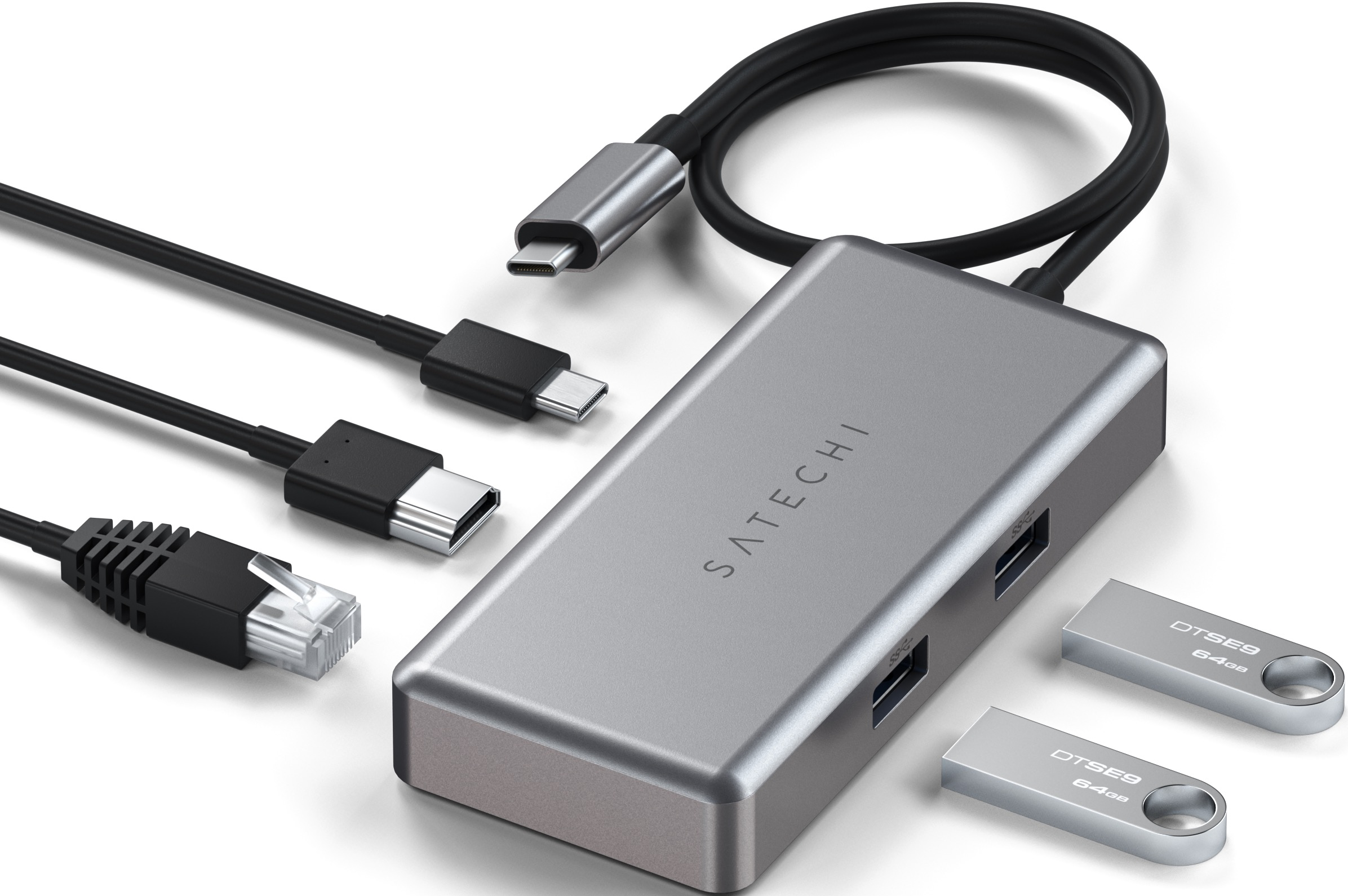Ein silberner USB-C-Hub mit verschiedenen Anschlüssen und angeschlossenen Kabeln. Zwei USB-Sticks sind ebenfalls vorhanden.