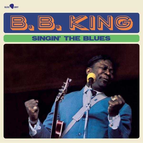 B.B. King énekel, gitárt tart, 'Singin' The Blues' album borító. Kék öltöny, mikrofon, színpadi háttér.