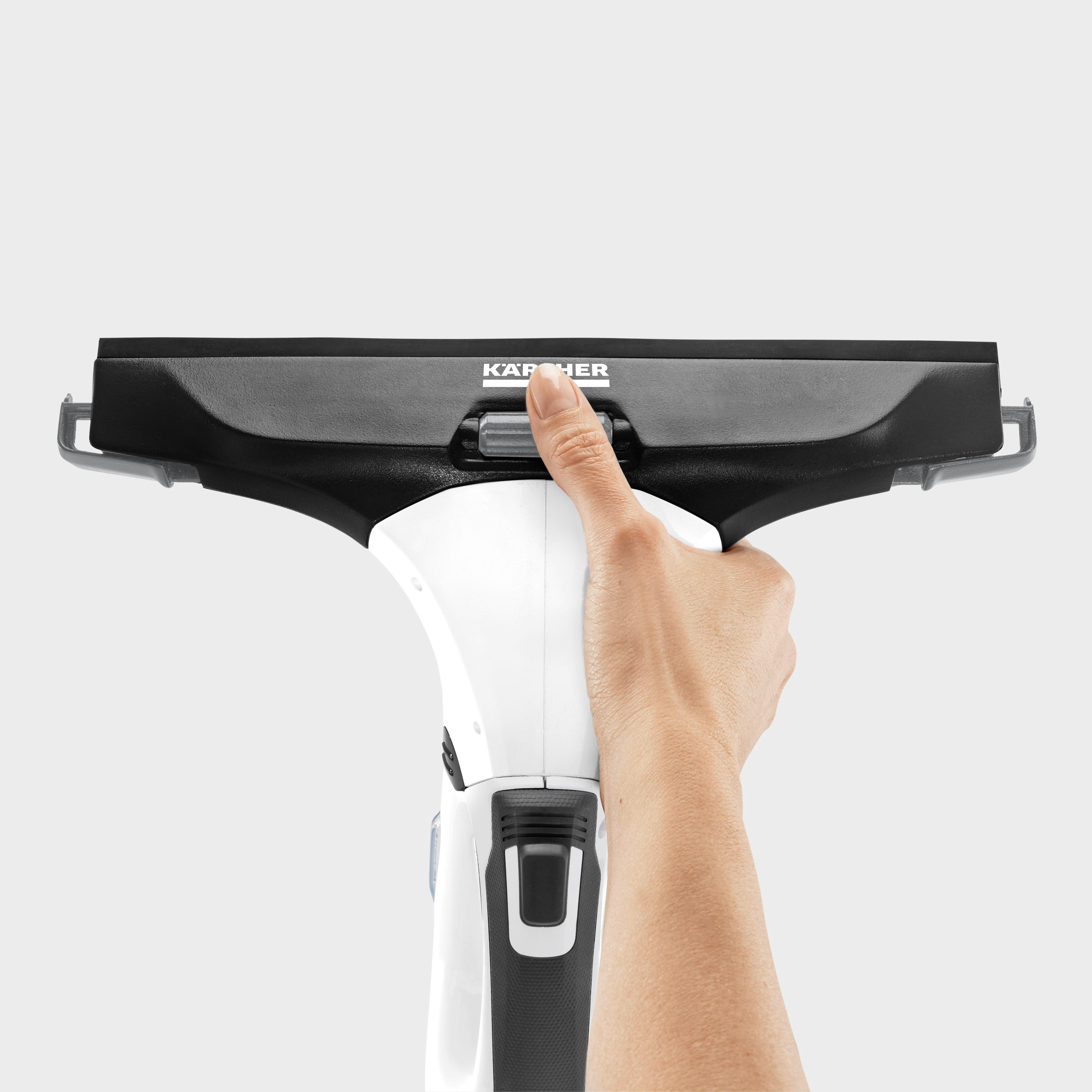 Hand drückt eine Taste auf einem weiß-schwarzen Fensterreiniger mit dem Wort 'Kärcher'.