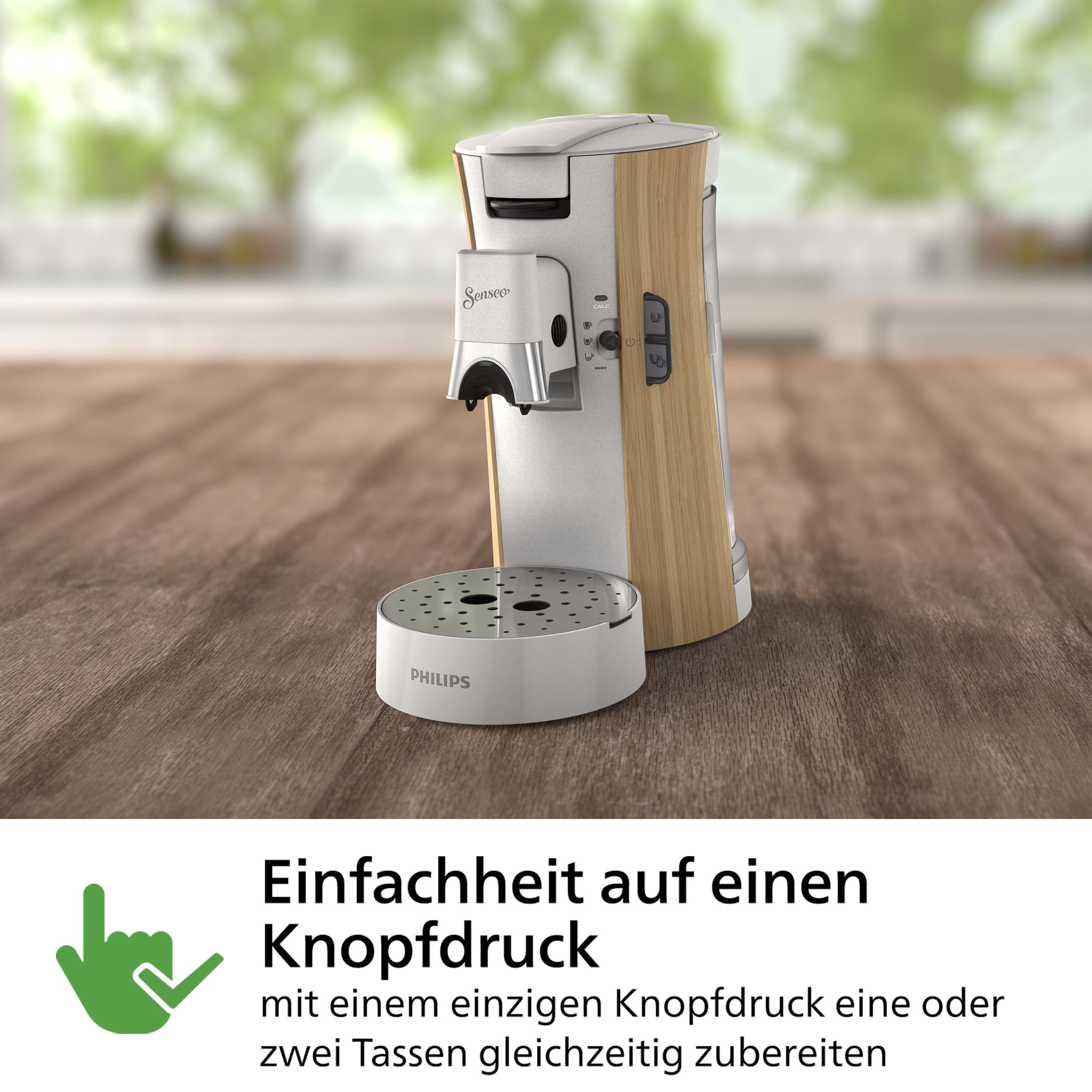 Eine weiße und holzfarbene Kaffeemaschine mit weißem Sockel auf einer Holzoberfläche.